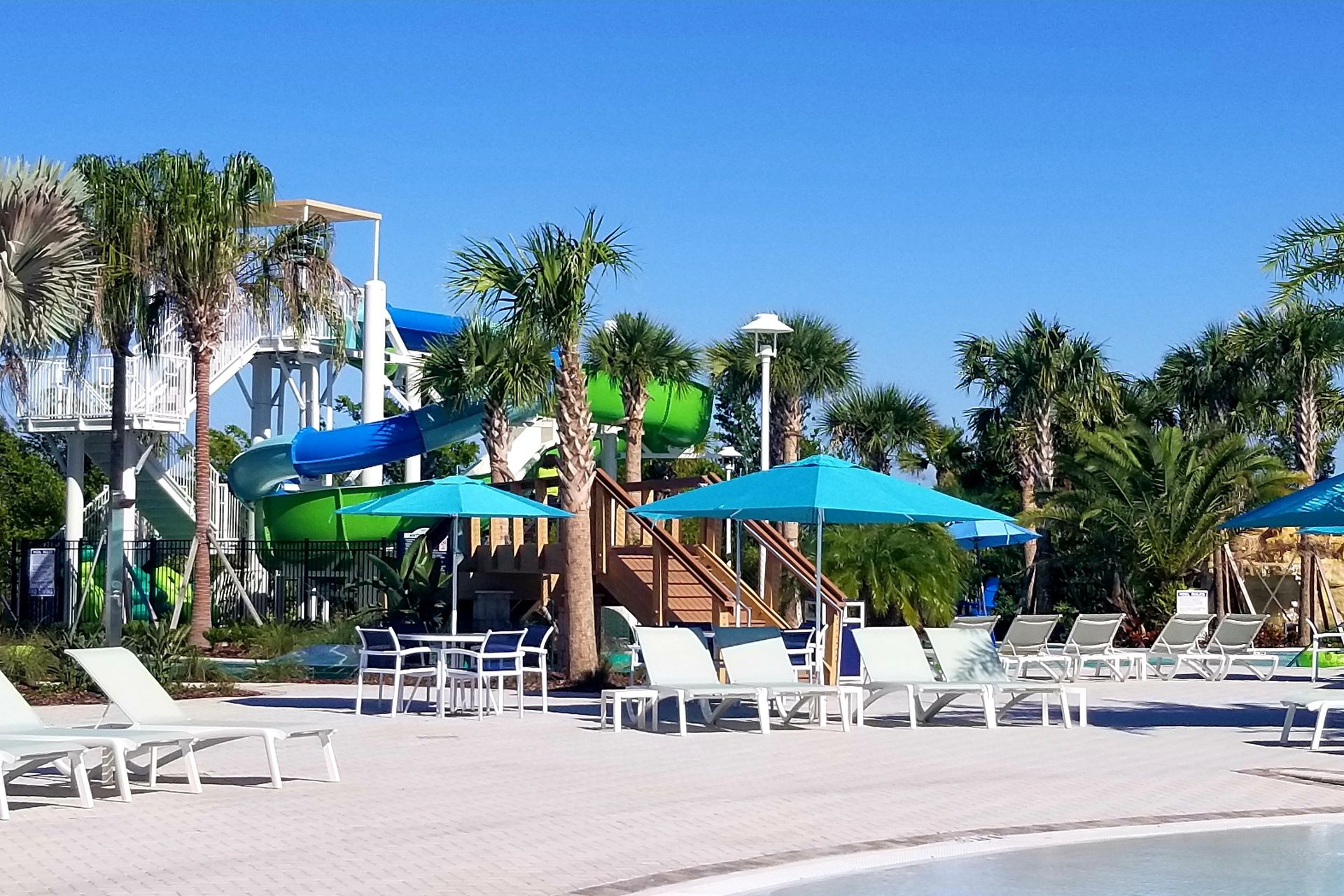 Relax in style by the resort lazy pool on comfortable table and chairs setup, offering you the perfect spot to unwind and soak up the serene ambiance.
