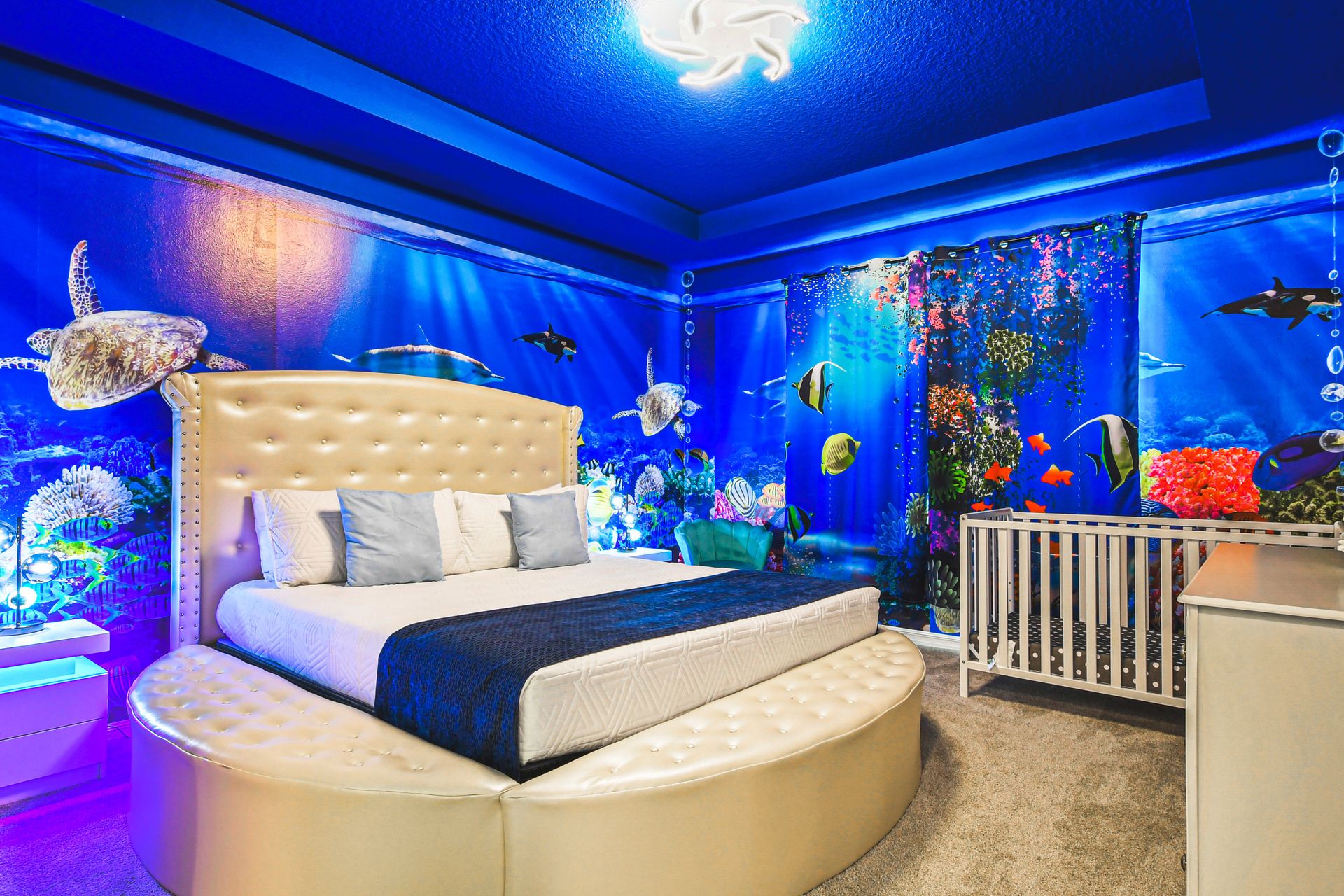 Ocean-inspired bedroom with vibrant aquatic murals and a crib!