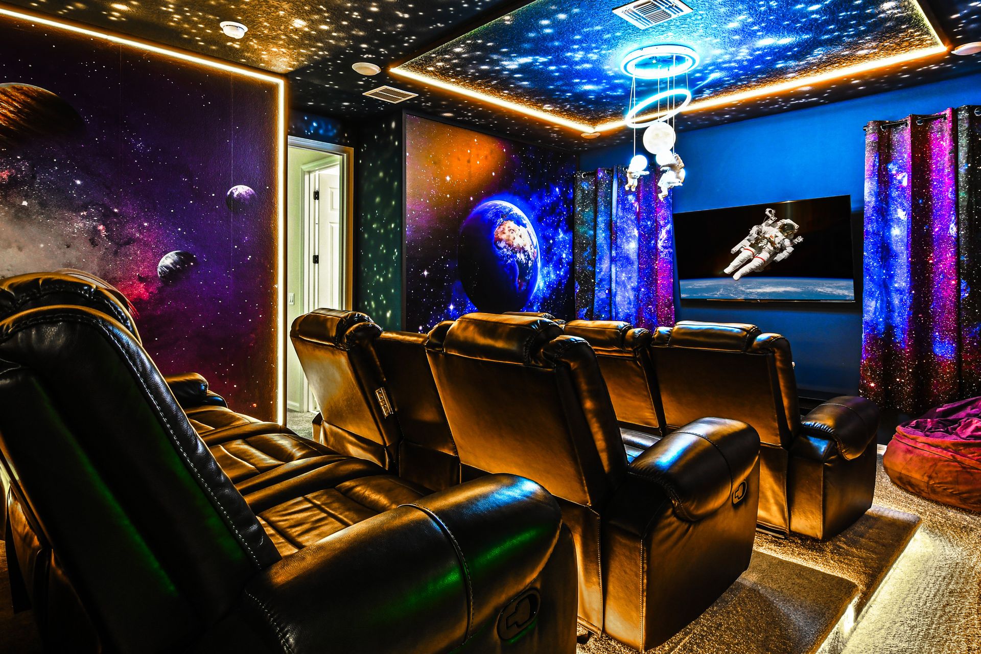 Cosmic home theater with reclining seats and breathtaking galaxy art!
