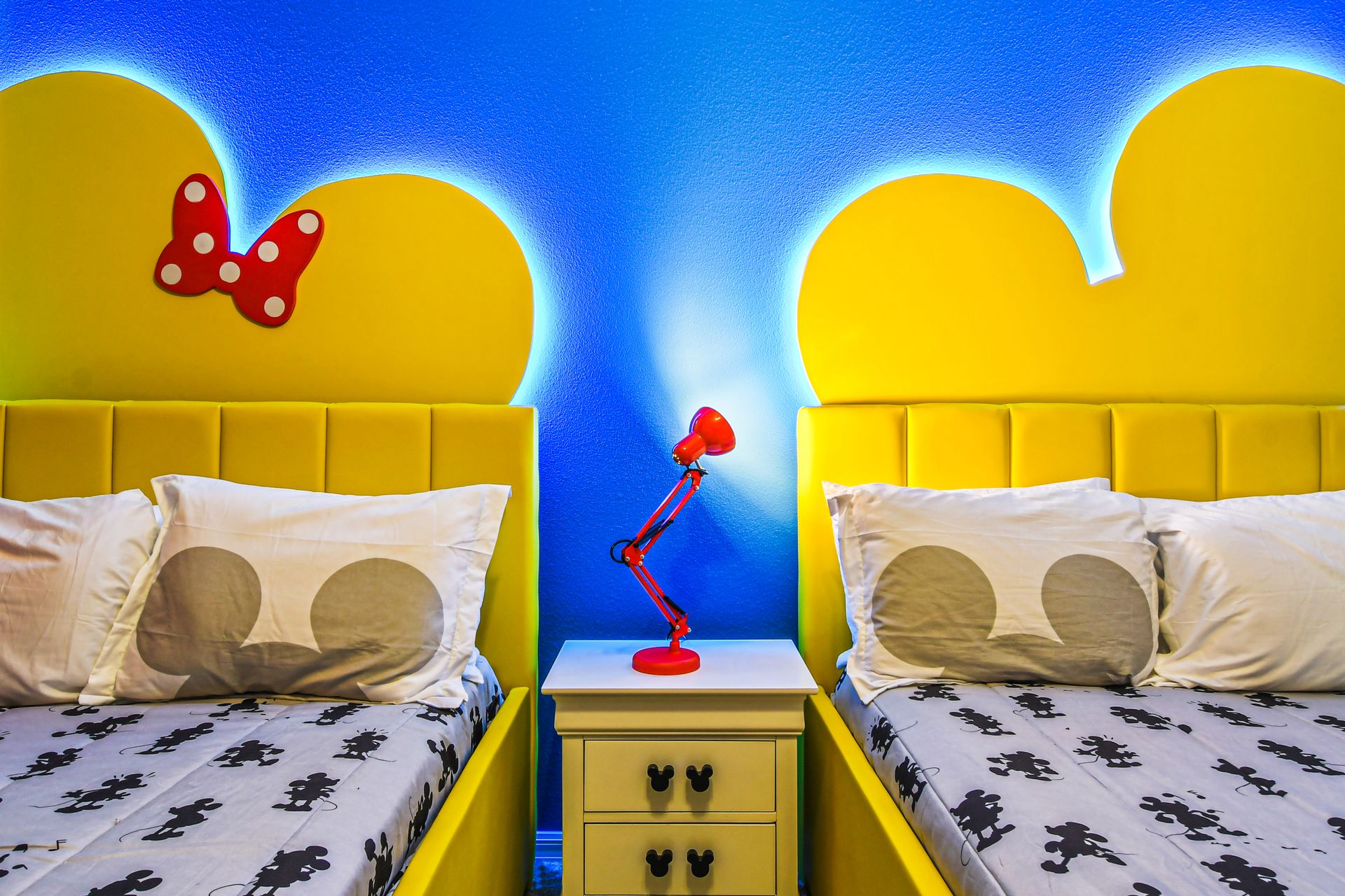 Vibrant twin beds with Mickey-shaped headboards and playful decor!
