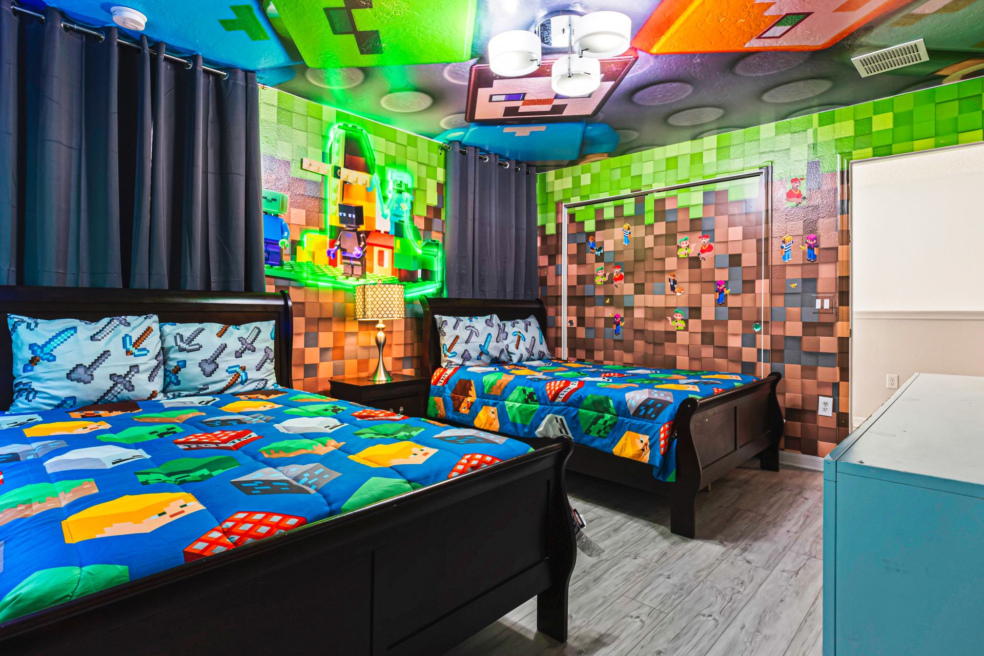 Gaming-themed bedroom with vibrant pixel art walls and bold, blocky bedding.
