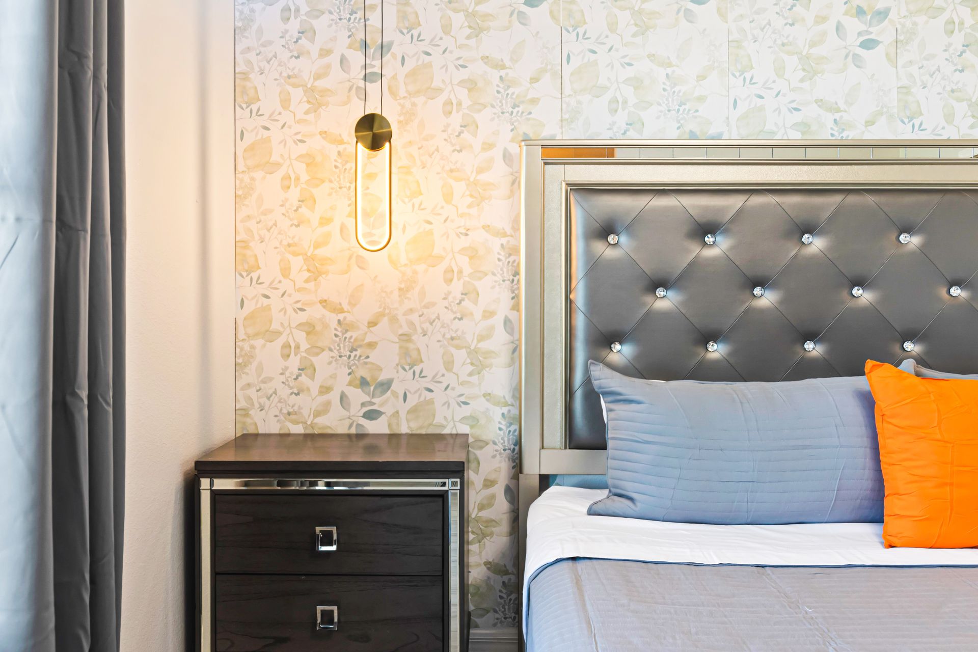 Chic king suite with tufted headboard, elegant lighting, and calming floral tones.