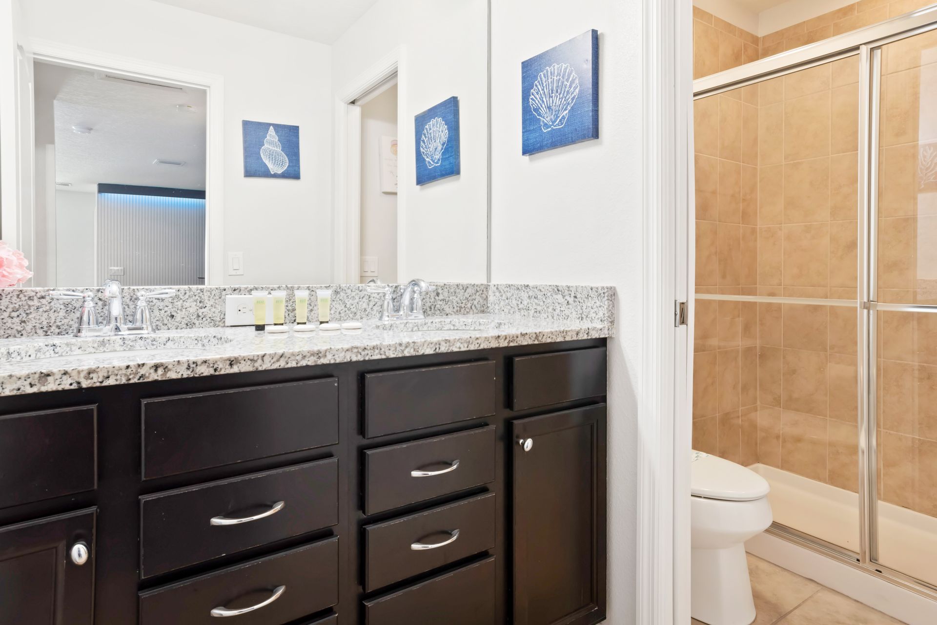 Elegant bathroom with granite countertop, tiled shower, and sleek modern finishes.
