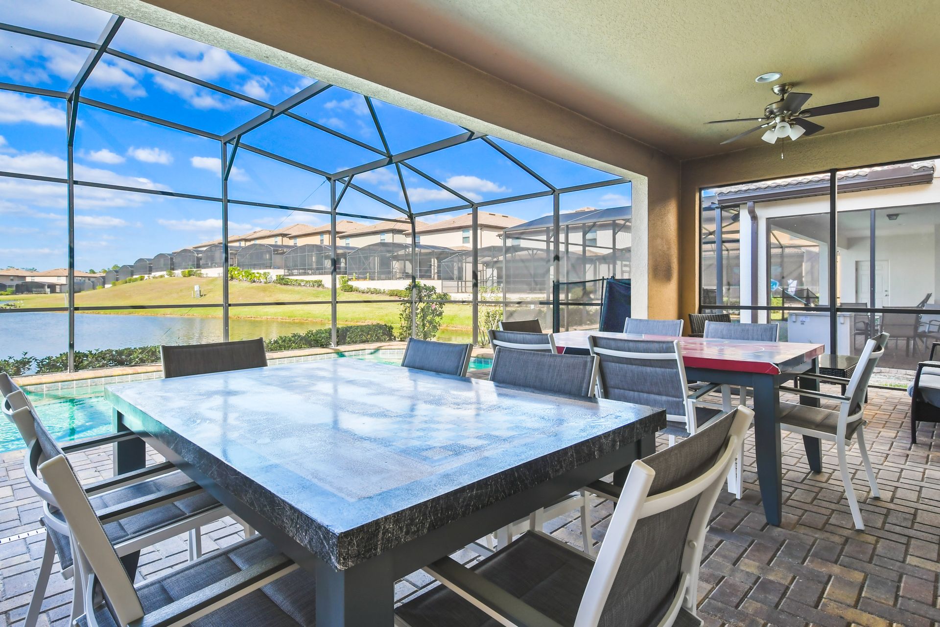 Covered patio with lake views, outdoor dining, ceiling fans, and a peaceful vibe.