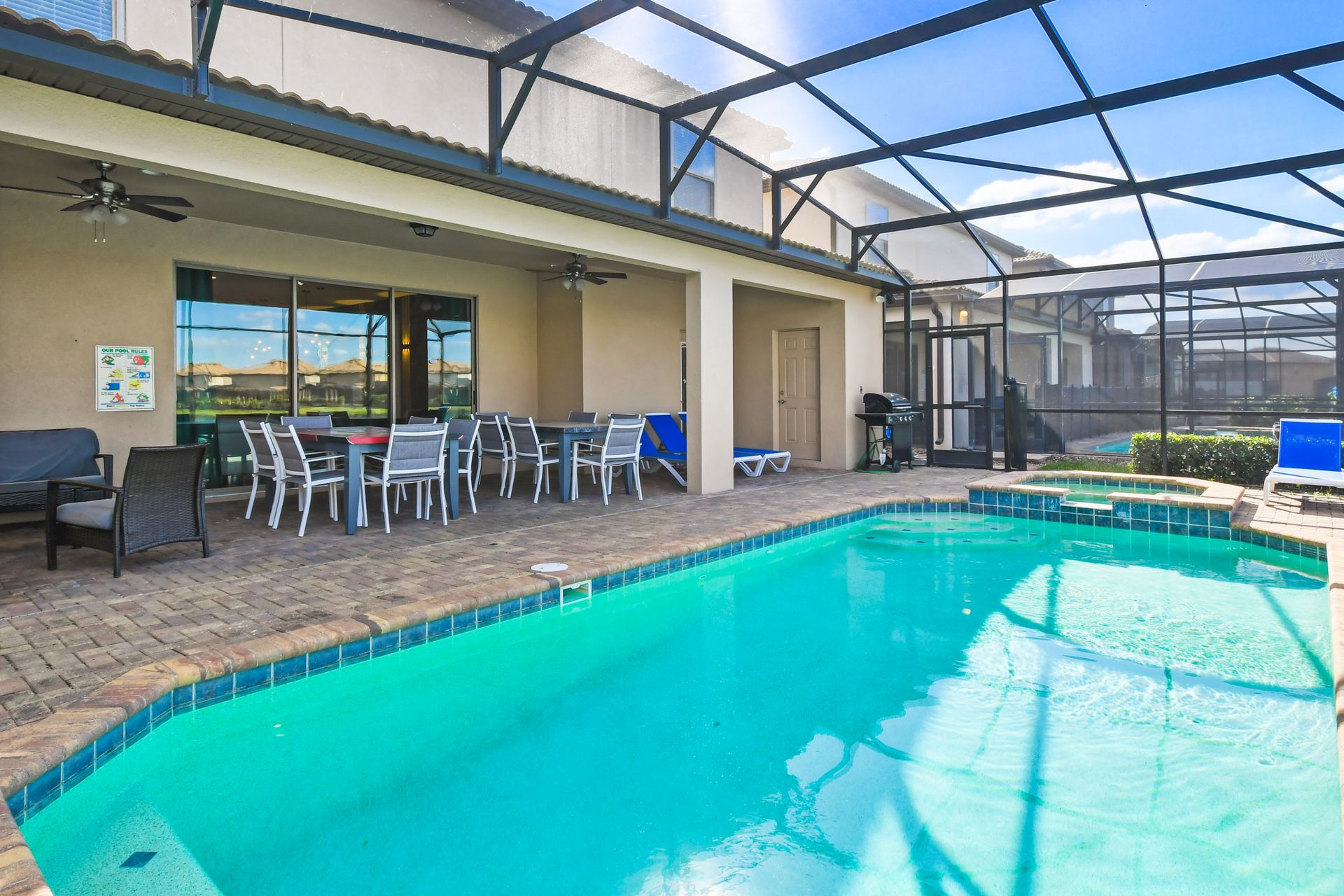 Private screened pool with spa, patio dining, loungers, grill, and serene views.