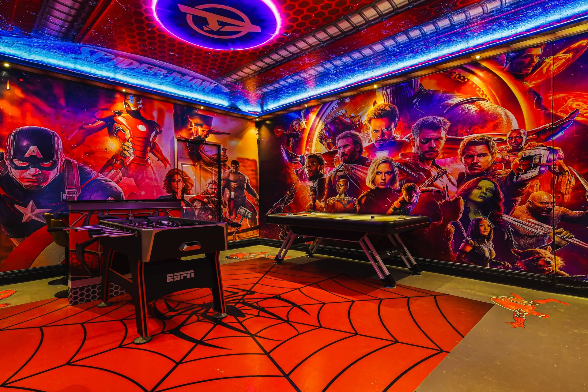 Marvel-themed game room with air hockey, foosball, and epic superhero murals.