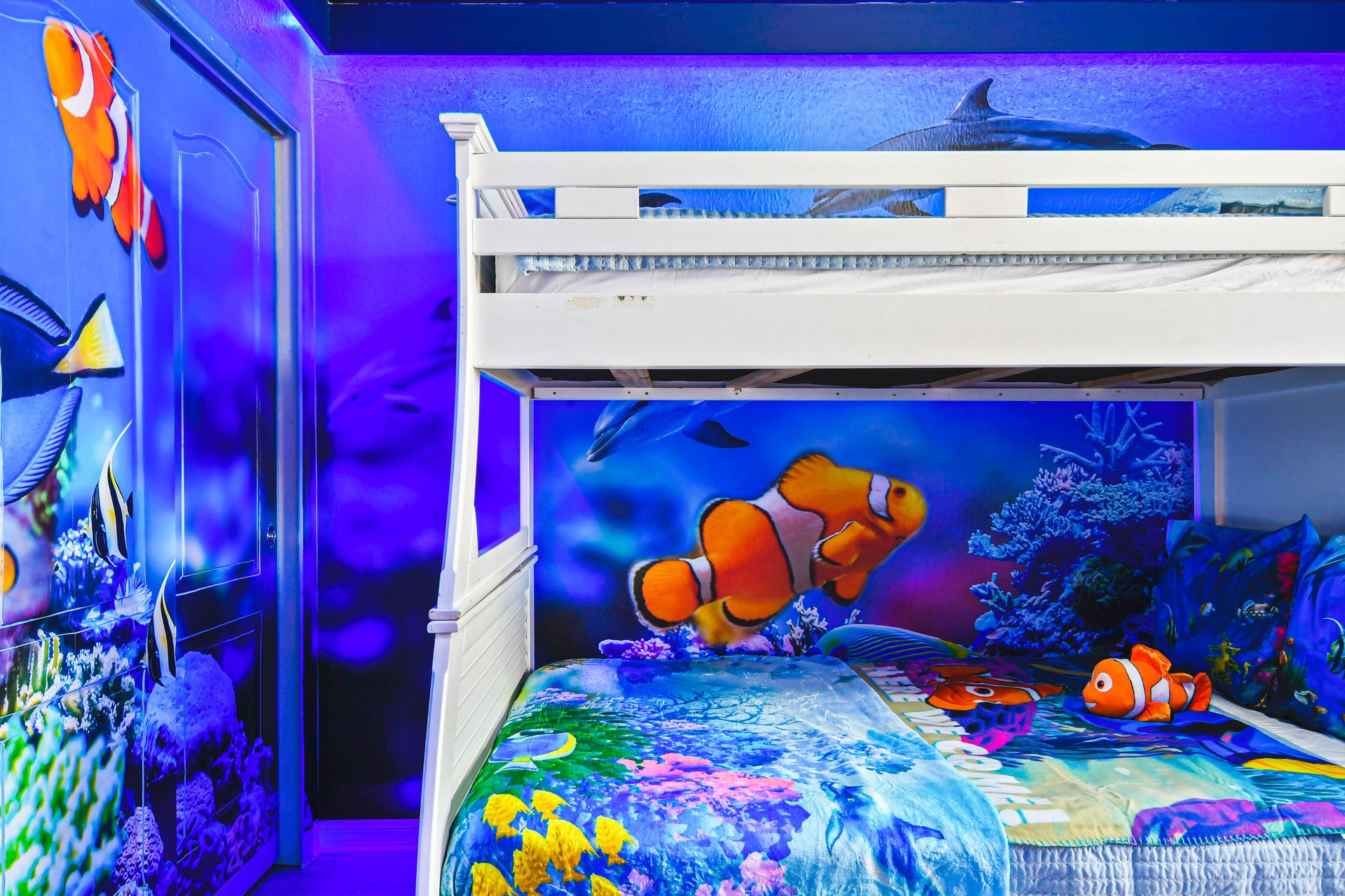 Underwater-themed kids room with bunk bed and vibrant ocean mural walls.