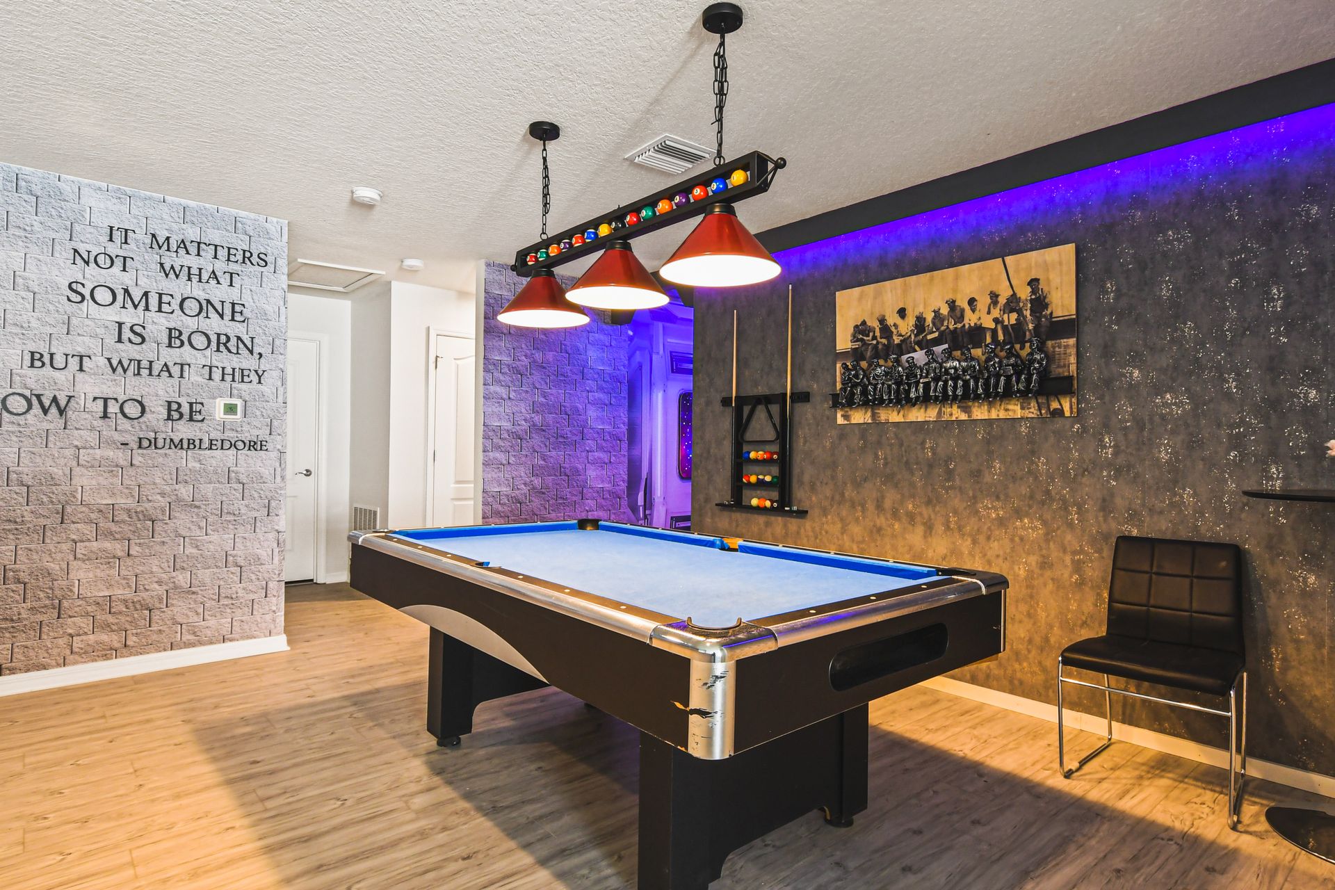 Stylish game room with pool table, seating, and inspirational décor wall.