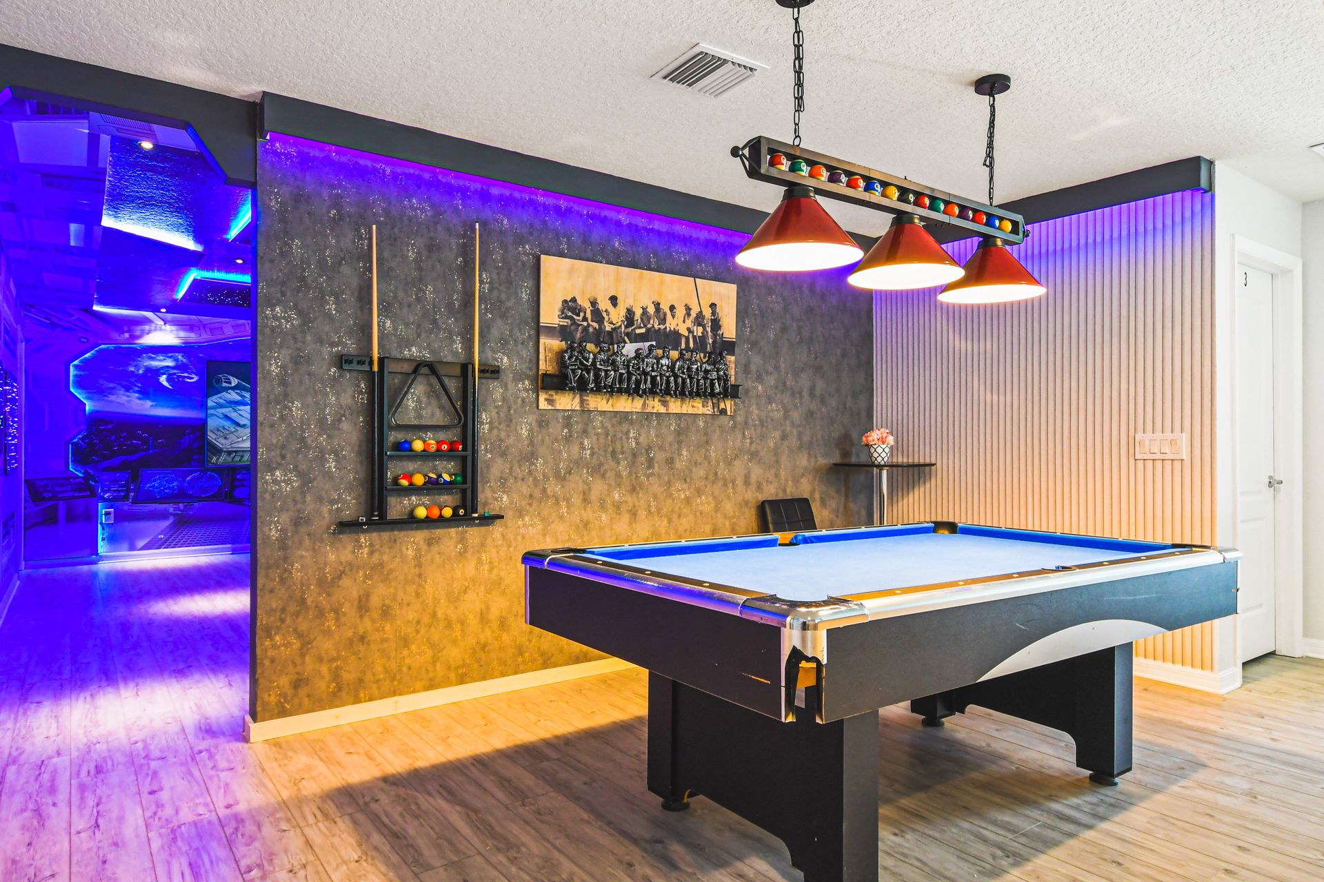 Game room with pool table and lounge, next to stunning galaxy-themed theater.
