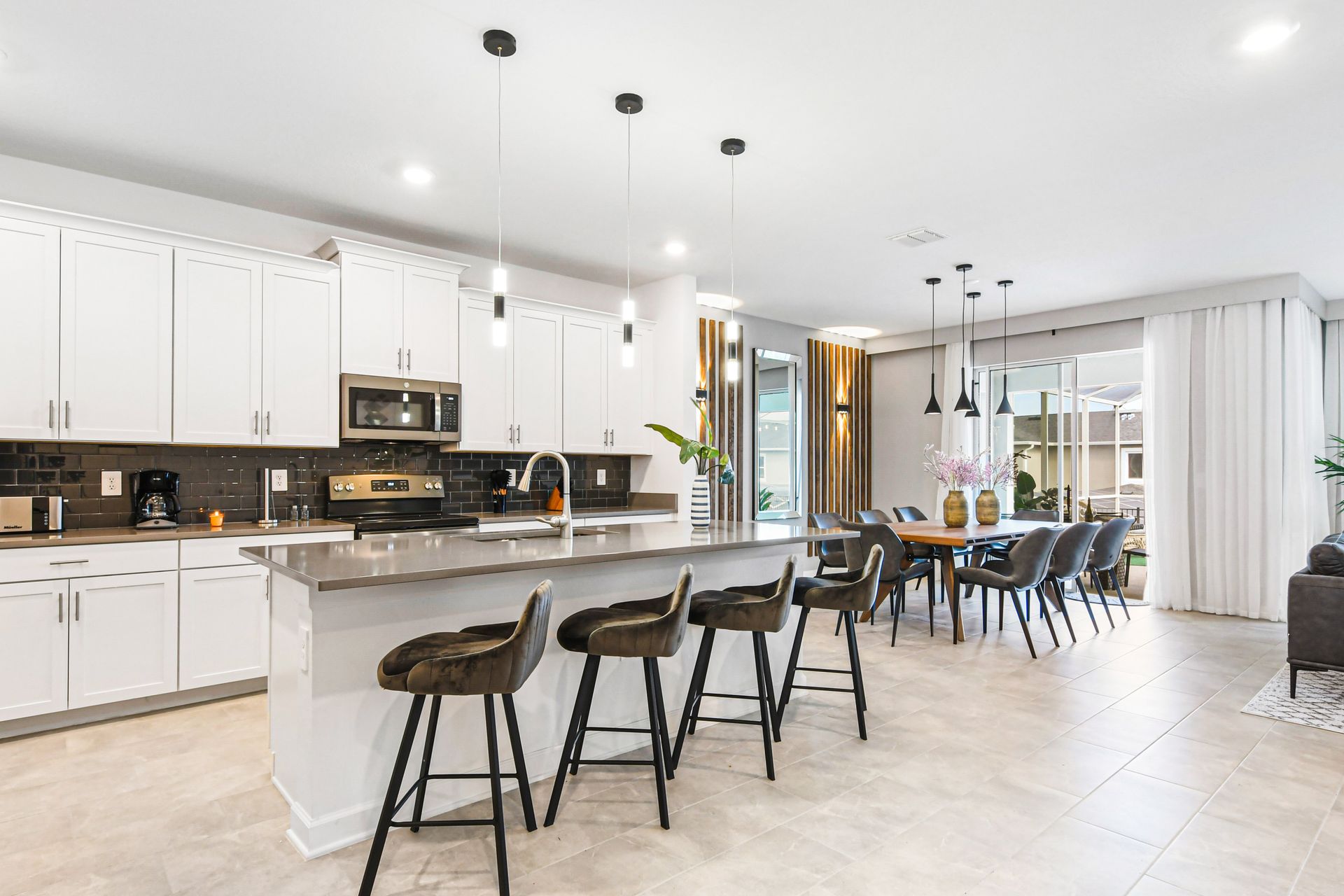 Spacious gourmet kitchen with sleek island, modern lighting, and open layout.