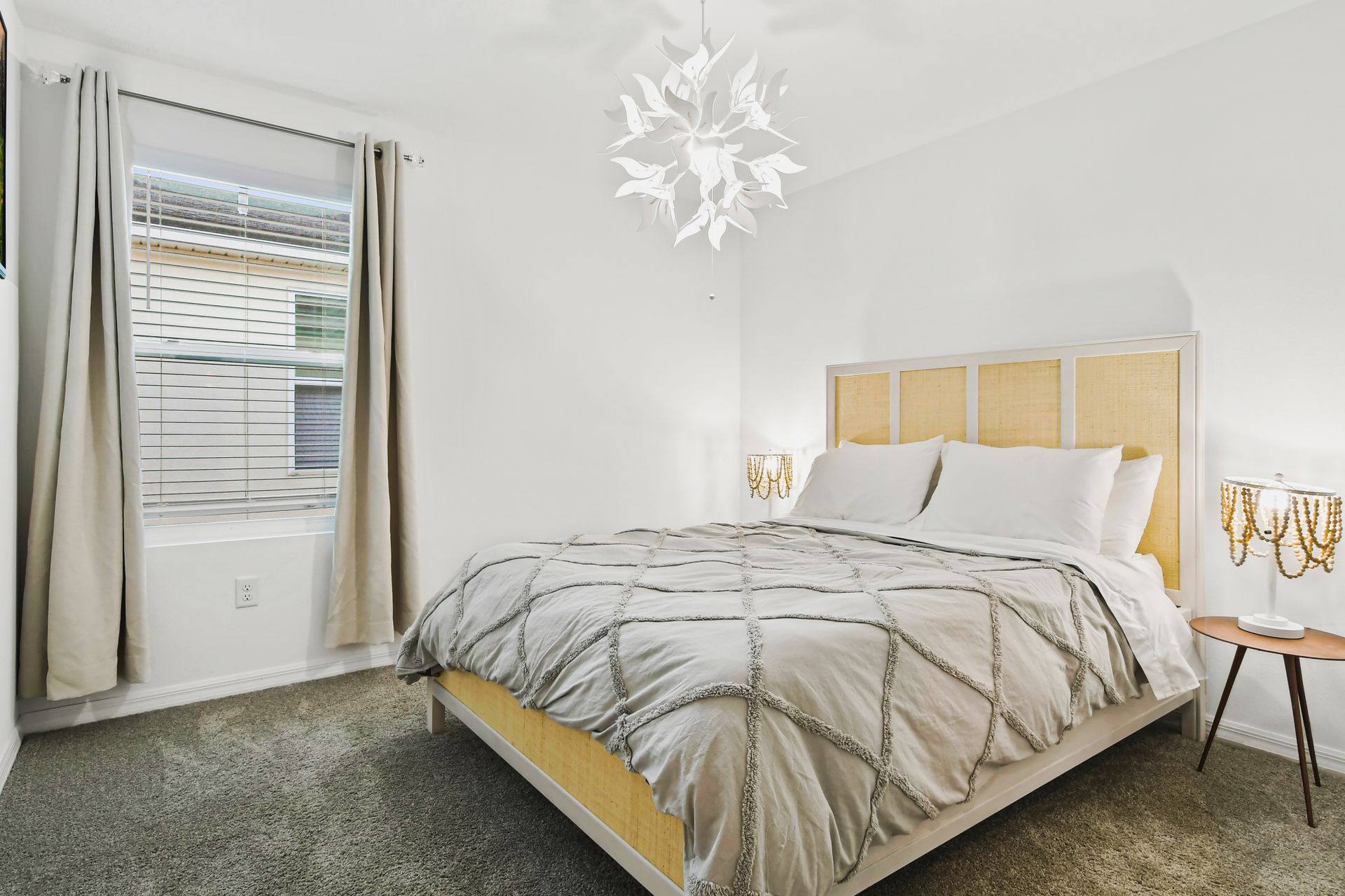 Minimalist bedroom with soft tones, elegant lighting, and a cozy queen bed.
