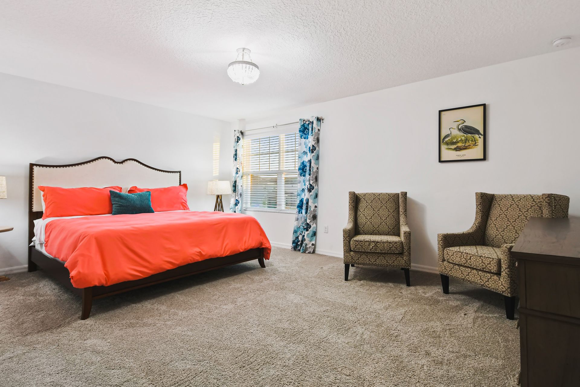Spacious bedroom with bright accents, cozy seating, and abundant natural light.