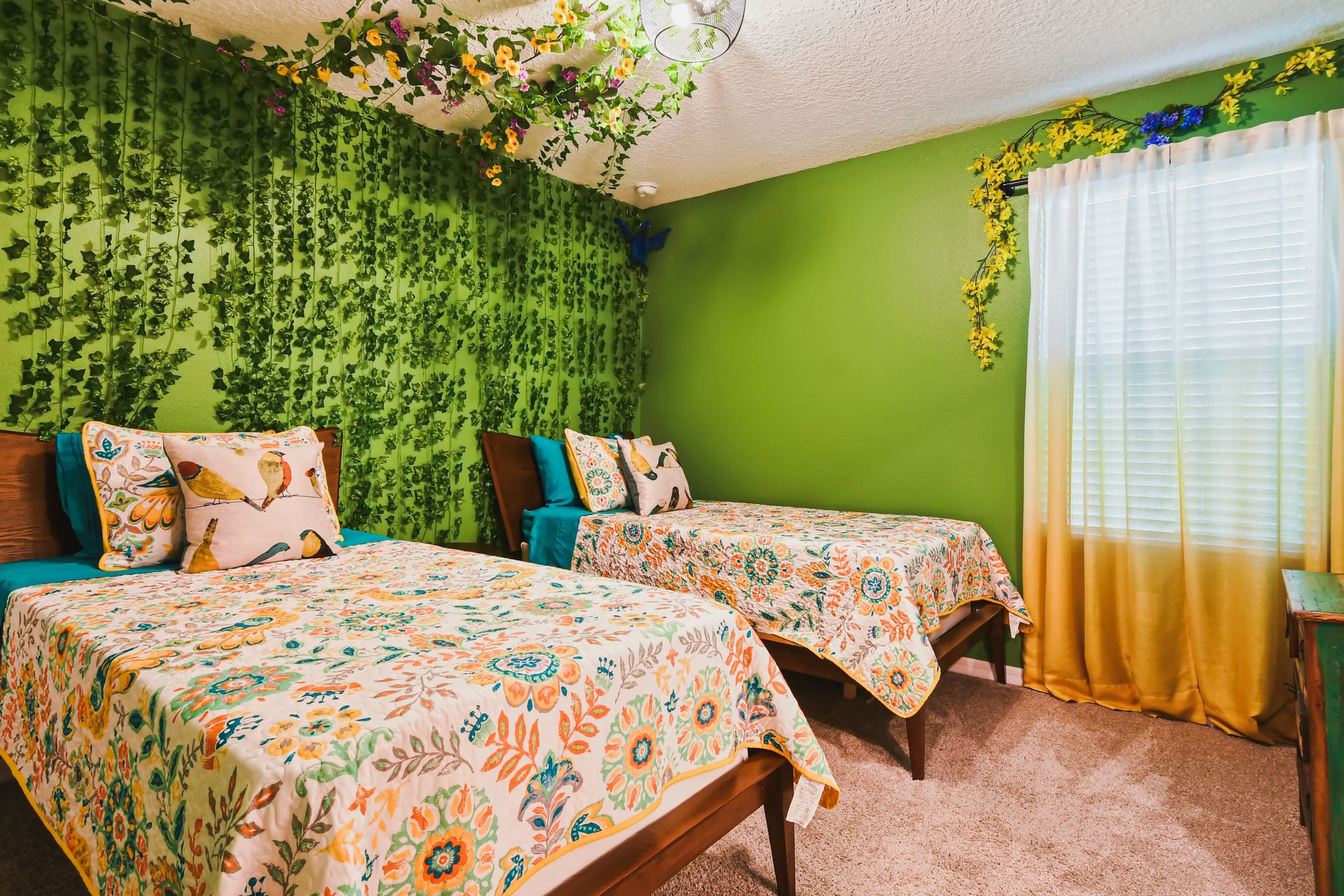Whimsical garden-themed room with vibrant greens, floral decor, and cozy twin beds.