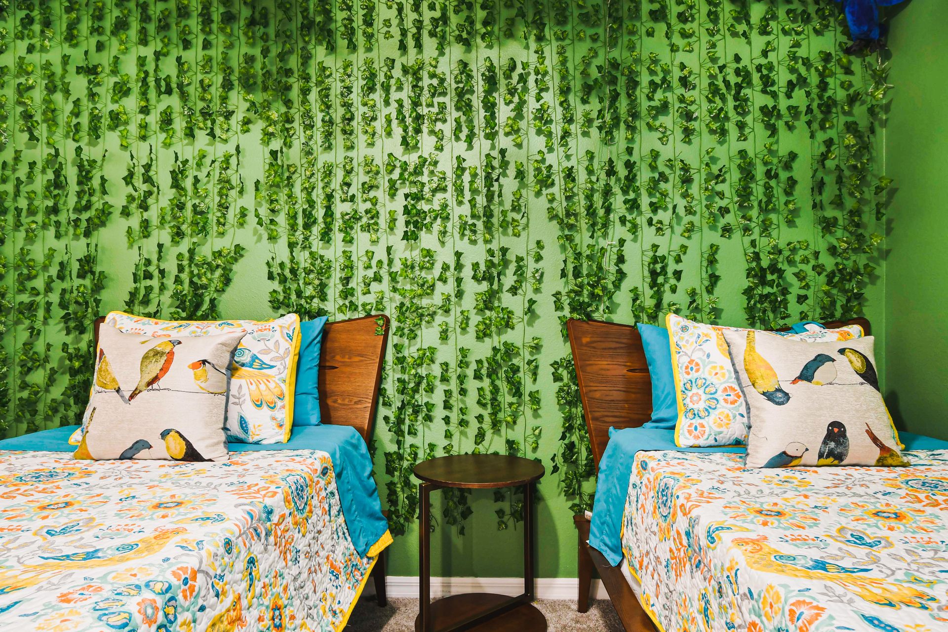 Whimsical garden-themed room with vibrant greens, floral decor, and cozy twin beds.
