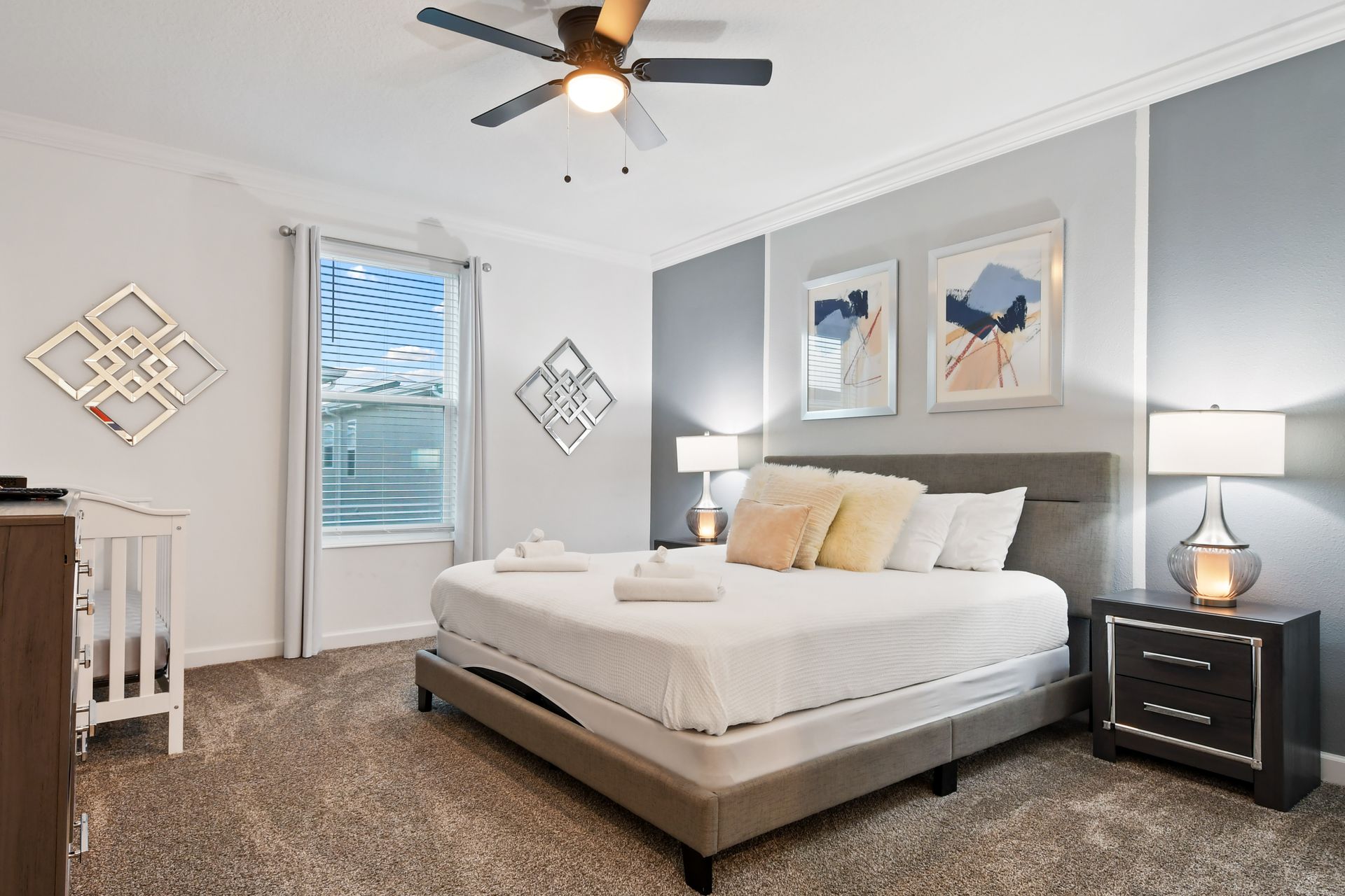 The master bedroom features a luxuriously large king bed with a crib