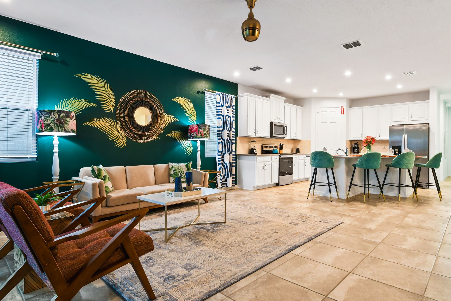 Spacious open-concept living with tropical decor, modern kitchen, and cozy seating.