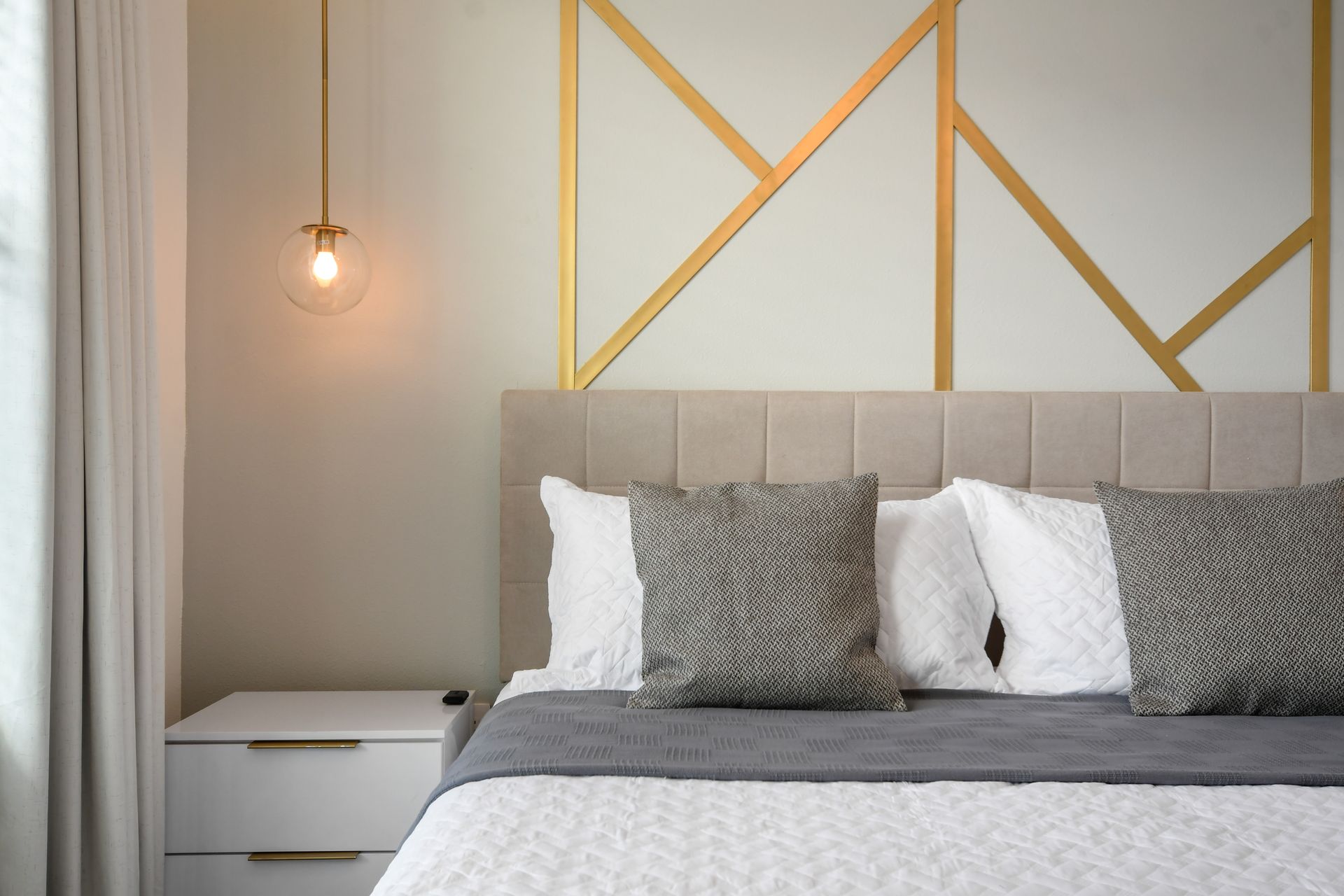 Modern glam bedroom with gold accents, soft neutrals, and stylish lighting touches.