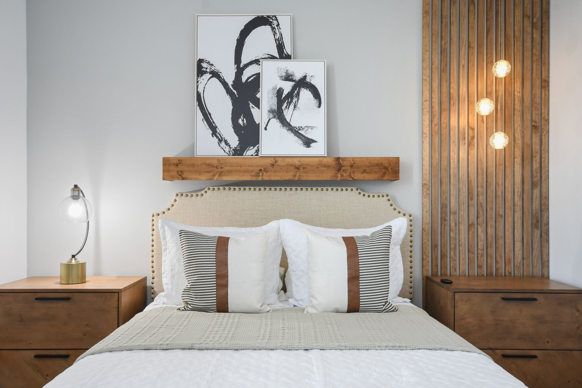 Cozy modern bedroom with wood accents, abstract art, and soft ambient lighting.
