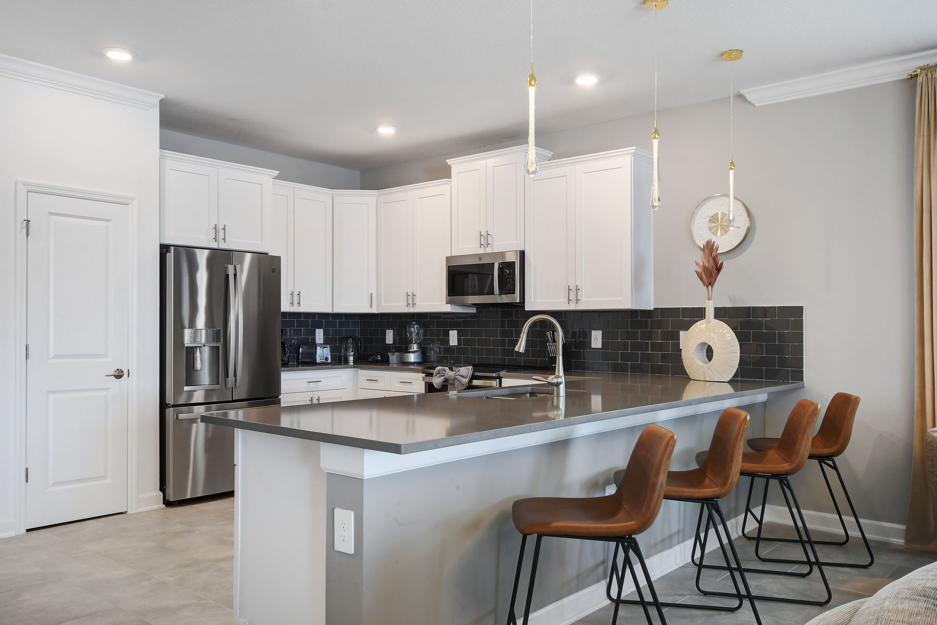Sleek chef’s kitchen with quartz counters, modern finishes, and seating for four.