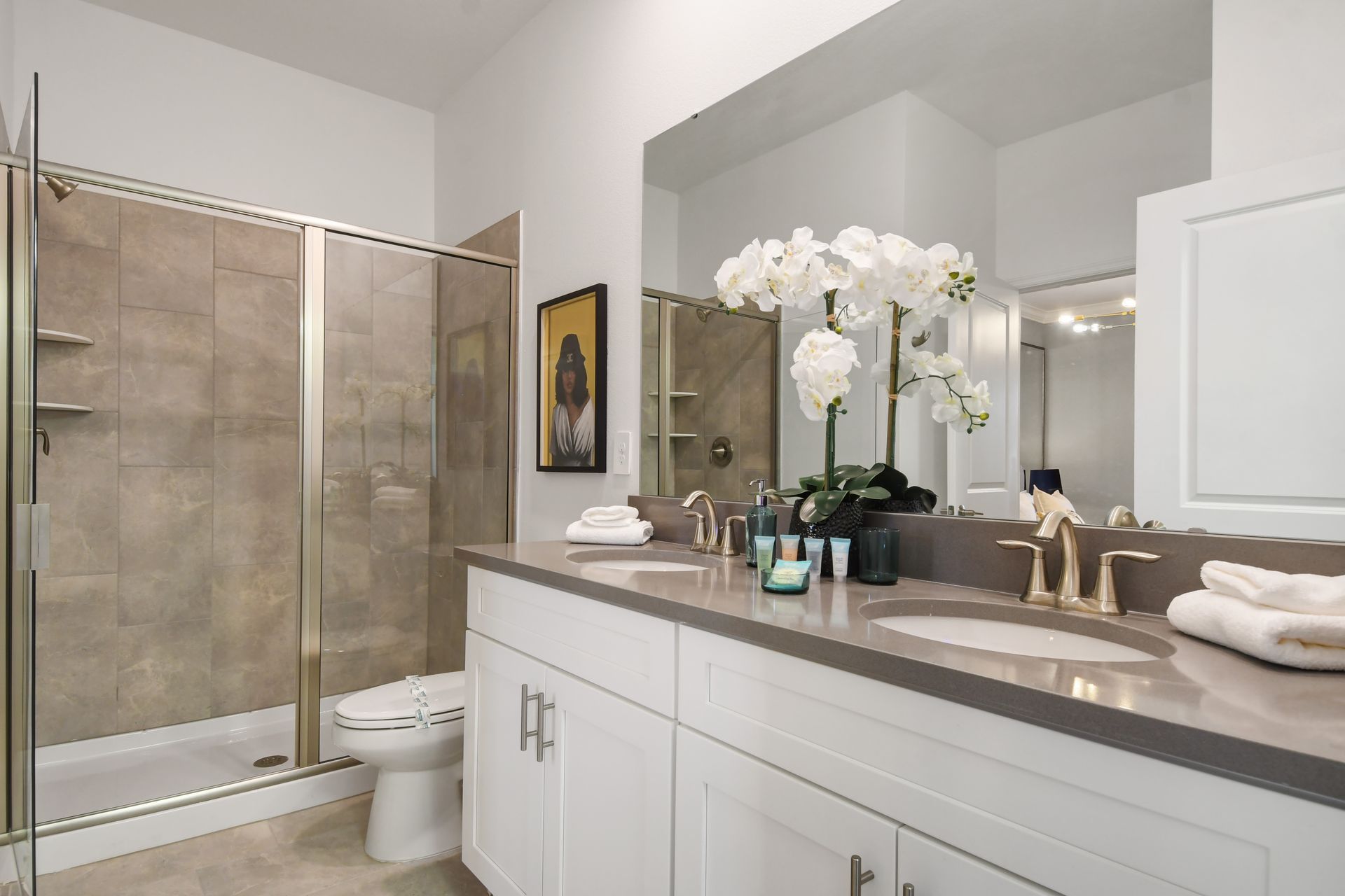 Elegant full bath with double vanity, glass walk-in shower, and luxe spa details.