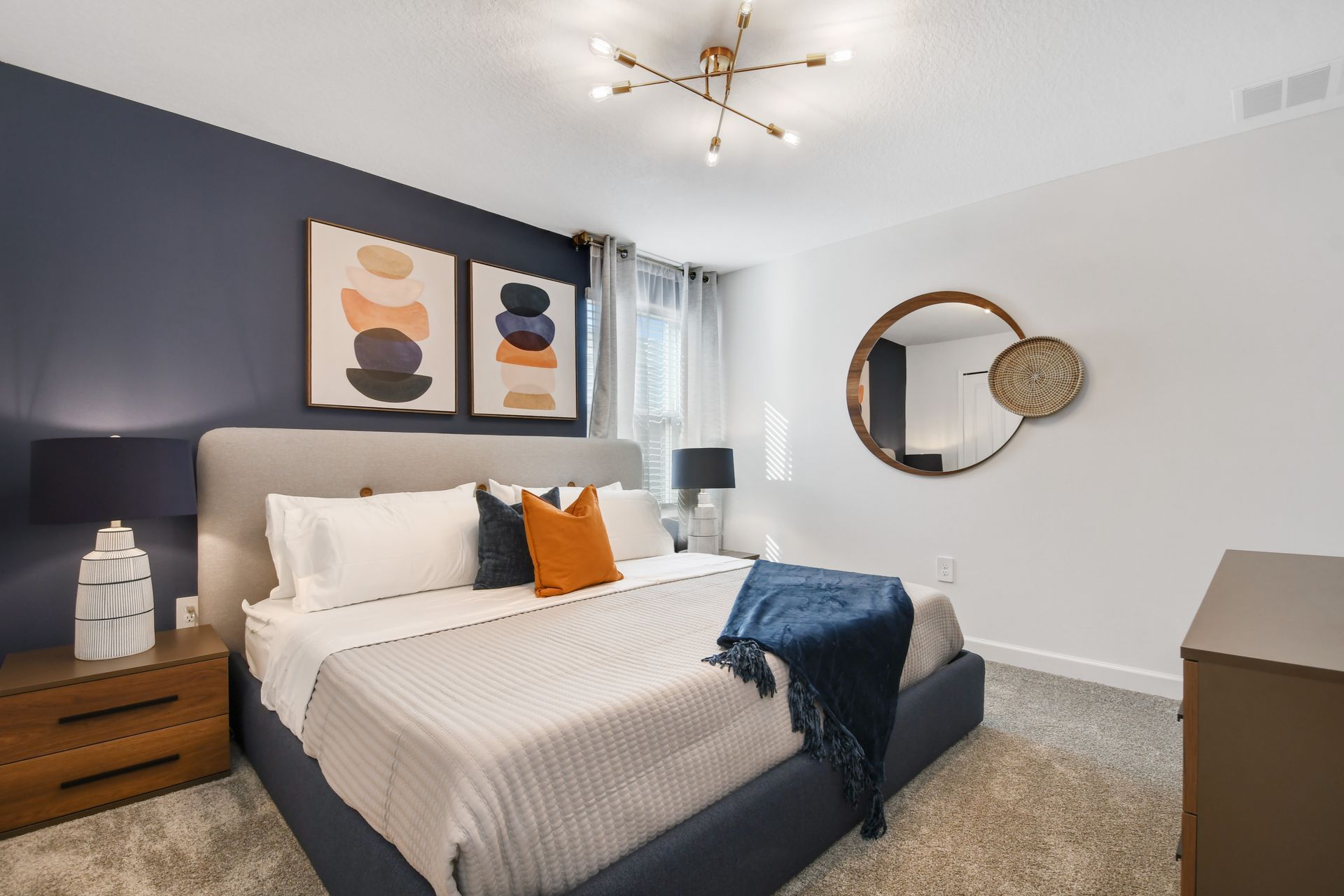 Bold and cozy bedroom with a king bed, modern lighting, and artistic flair.