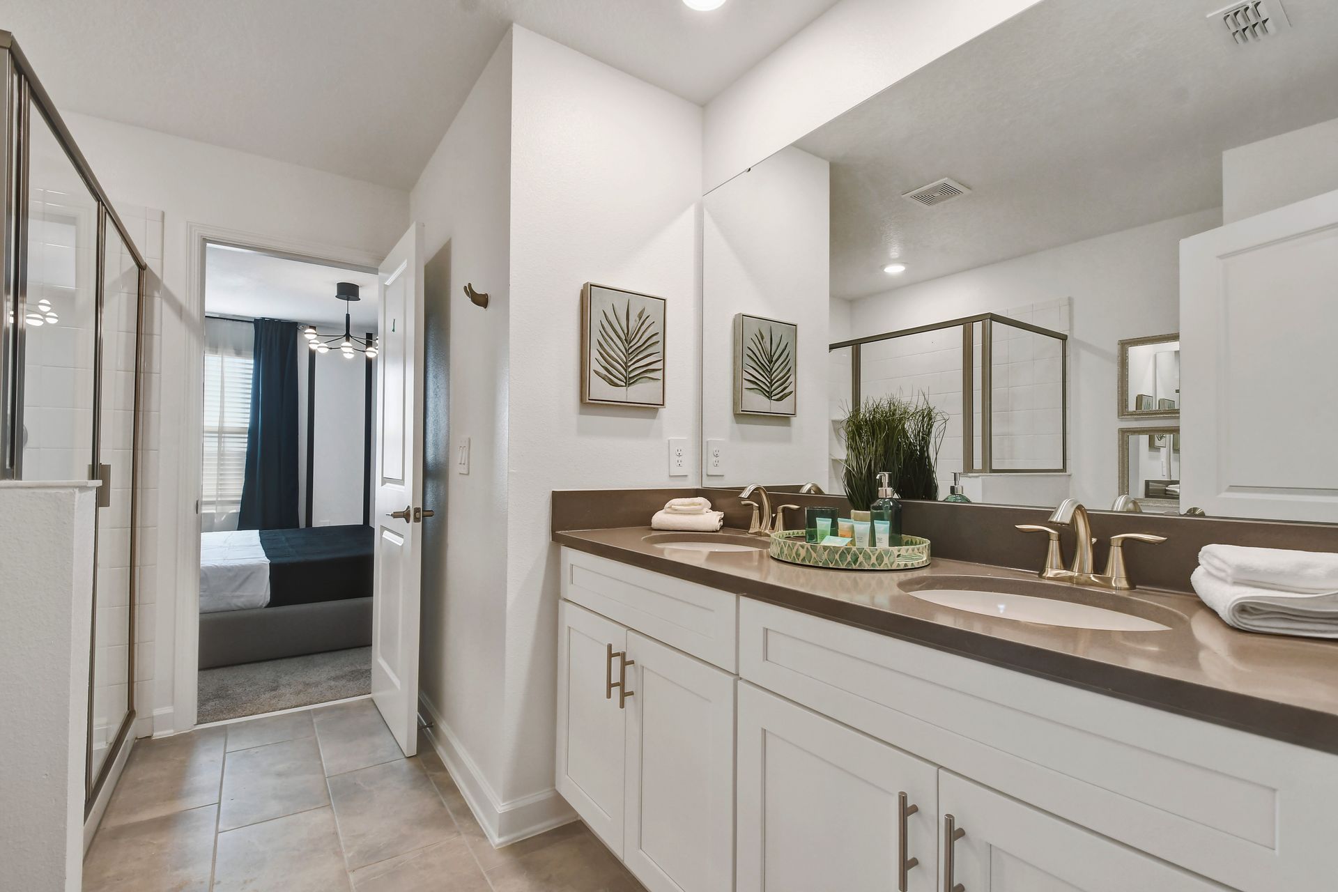 Spa-style bathroom with dual sinks, walk-in shower, and calming modern finishes.