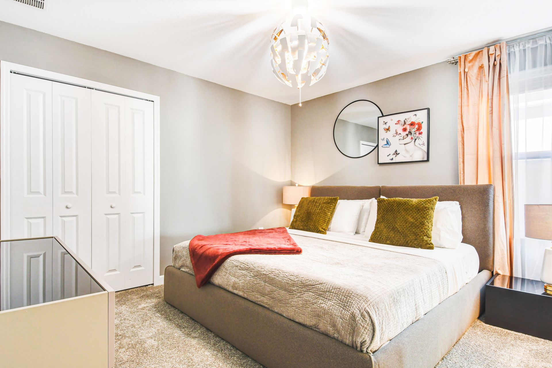 Stylish queen bedroom with vibrant accents, cozy textures, and a smart TV setup.