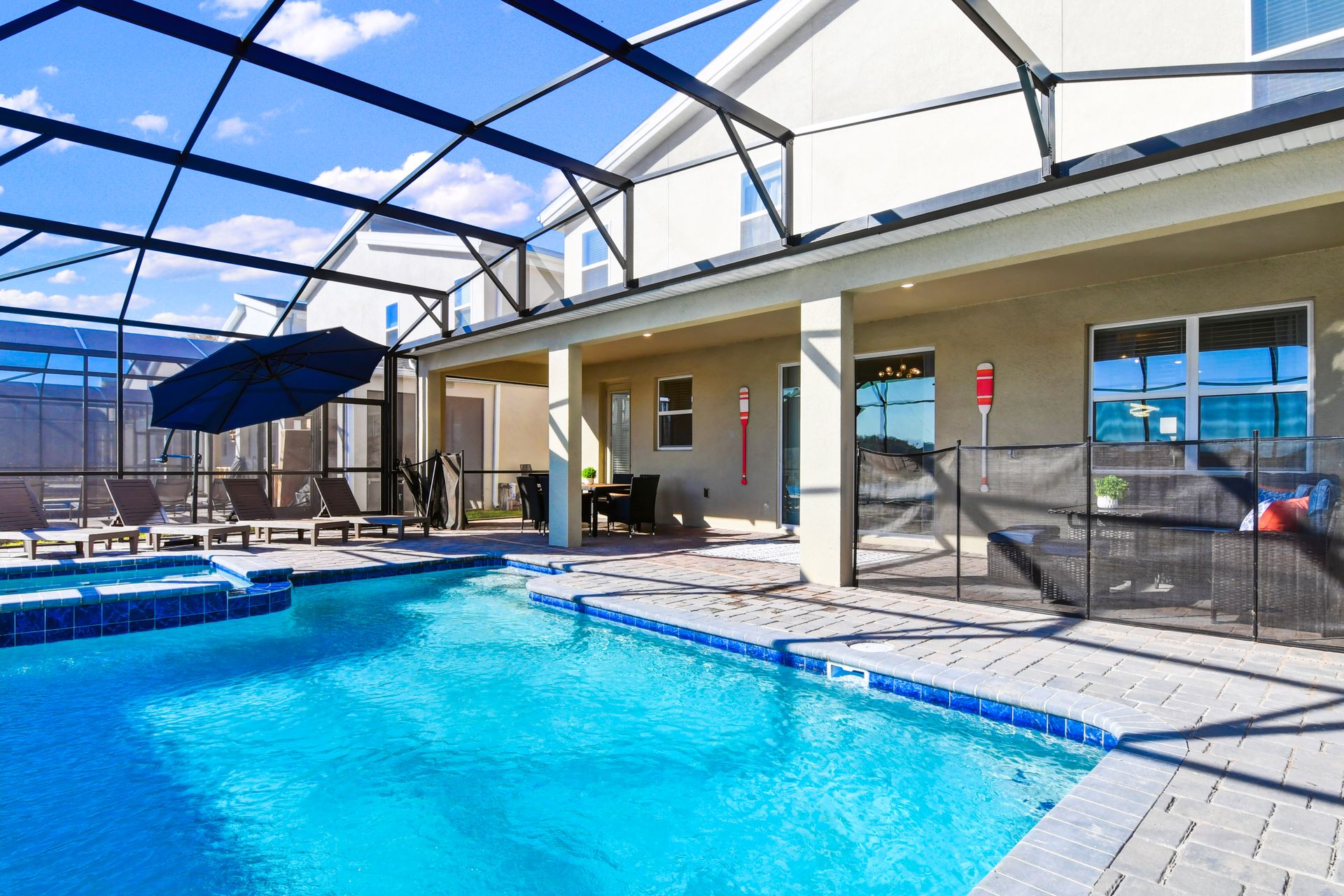 Dive into relaxation with a private screened pool, hot tub, loungers, and patio seating.