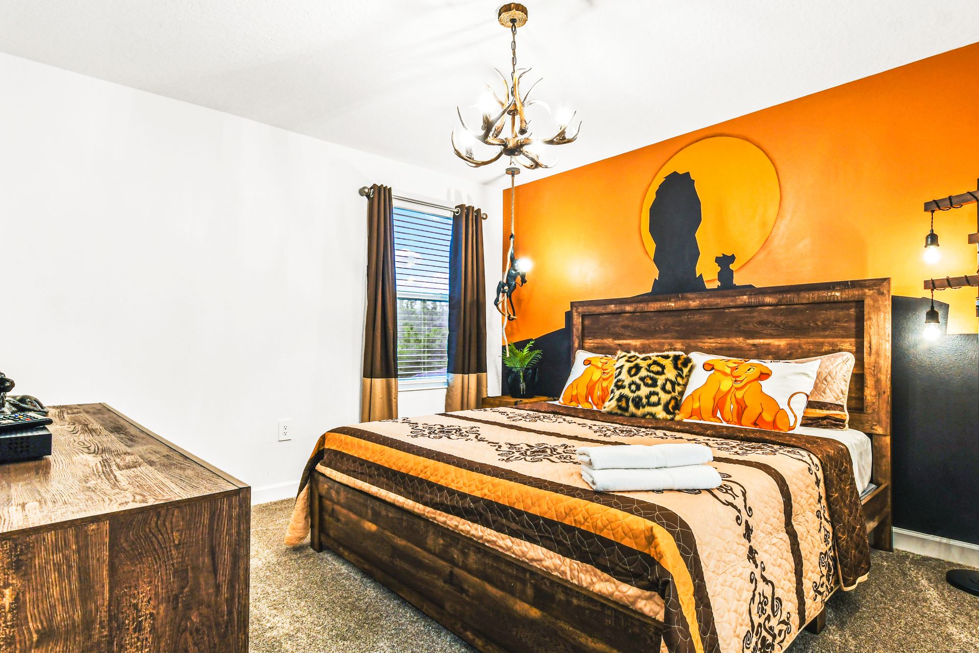 Safari-style Lion King room with sunset mural and warm, wild-hearted charm.