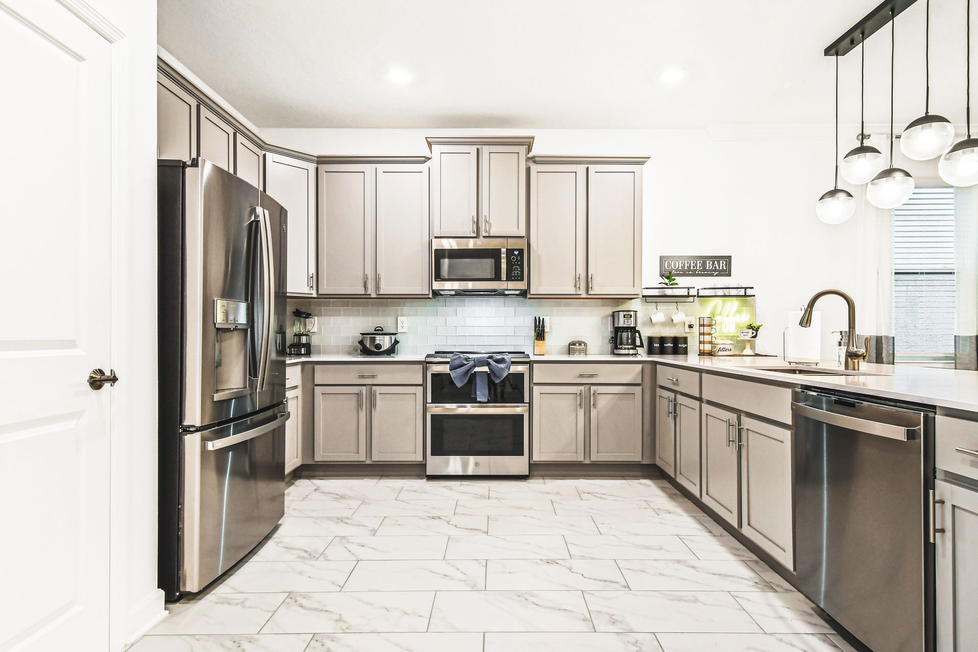 Spacious chef’s kitchen with stainless steel appliances and a stylish coffee bar.