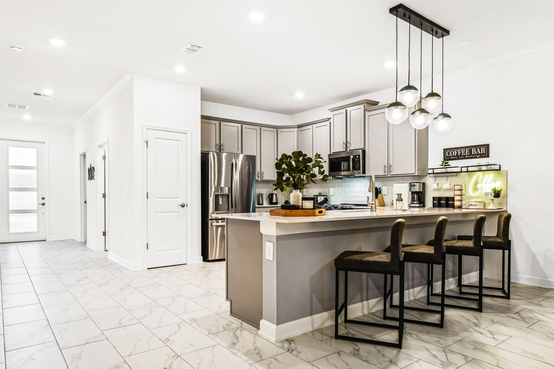 Bright, modern kitchen with island seating, pendant lighting, and coffee station.