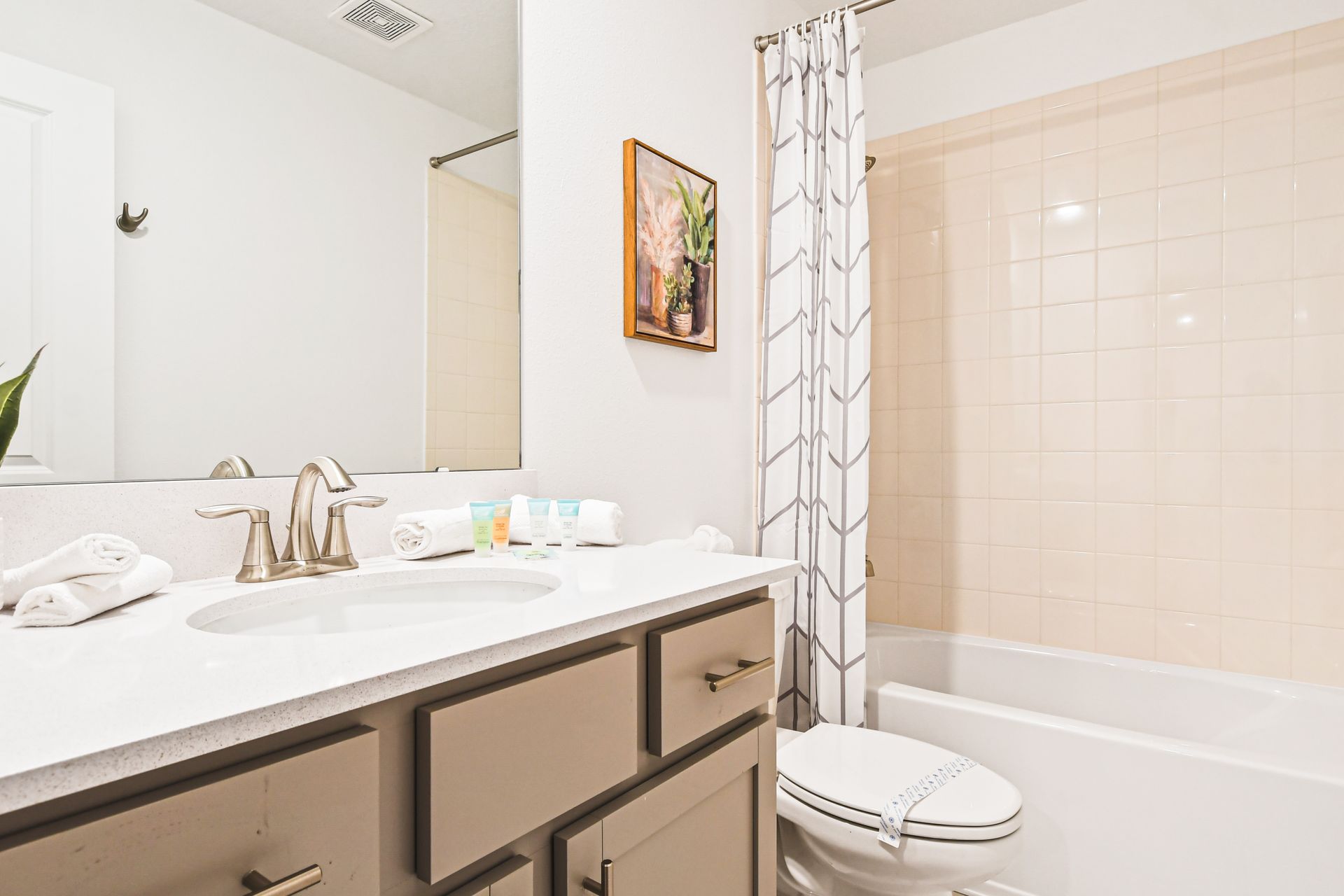 Bright, modern bathroom with fresh towels, full tub, and spa-style amenities.