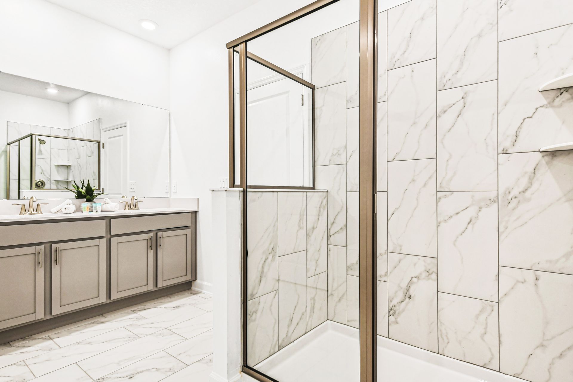 Spacious ensuite with marble walk-in shower, double vanity, and modern flair.