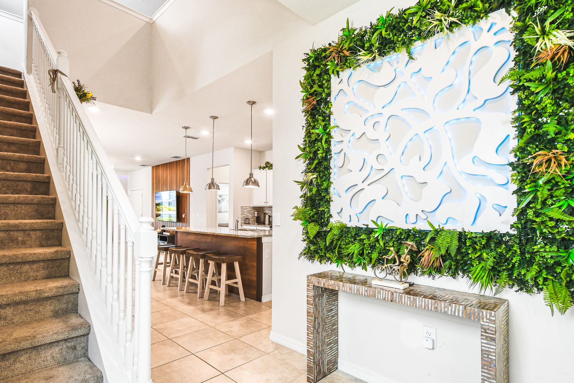 Welcoming entryway with a lush green wall and modern decor, setting the tone for a vibrant home!