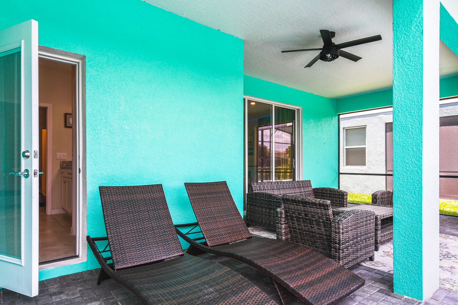 Inviting turquoise patio with comfy seating—perfect for lounging and enjoying the breeze!