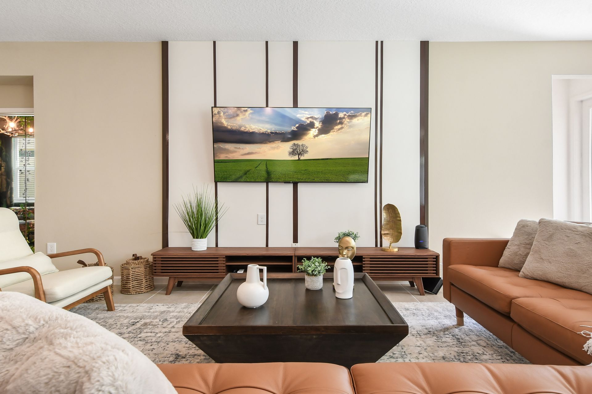 Modern living room with sleek furniture, neutral tones, and a serene TV display.