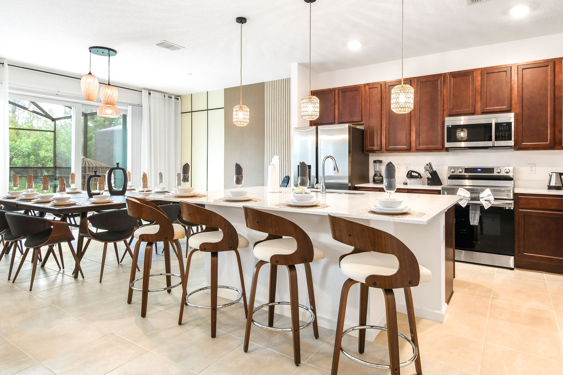 Spacious kitchen and dining area with modern appliances, elegant lighting, and ample seating.