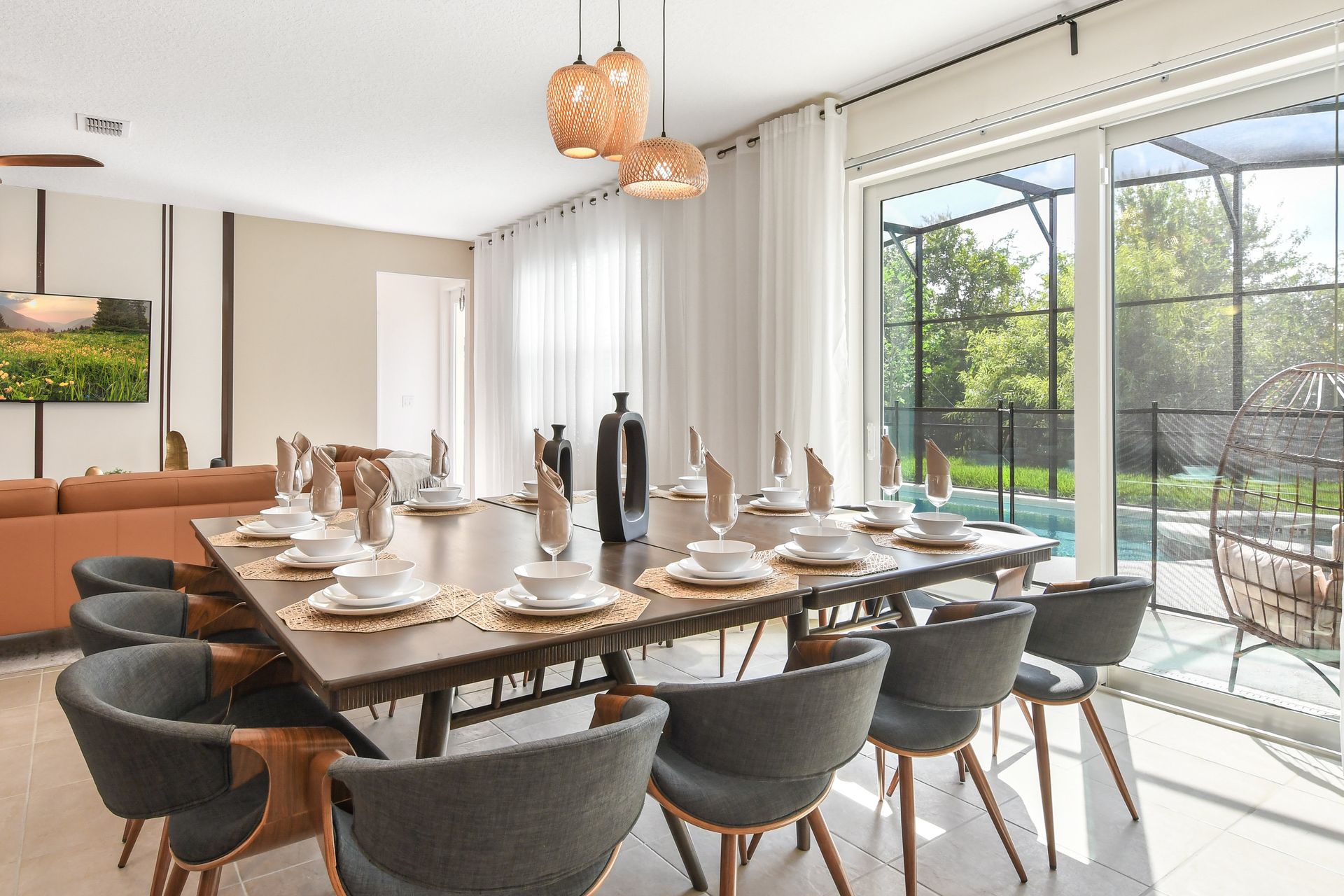 Bright dining area with modern decor, pool views, and natural light streaming in.