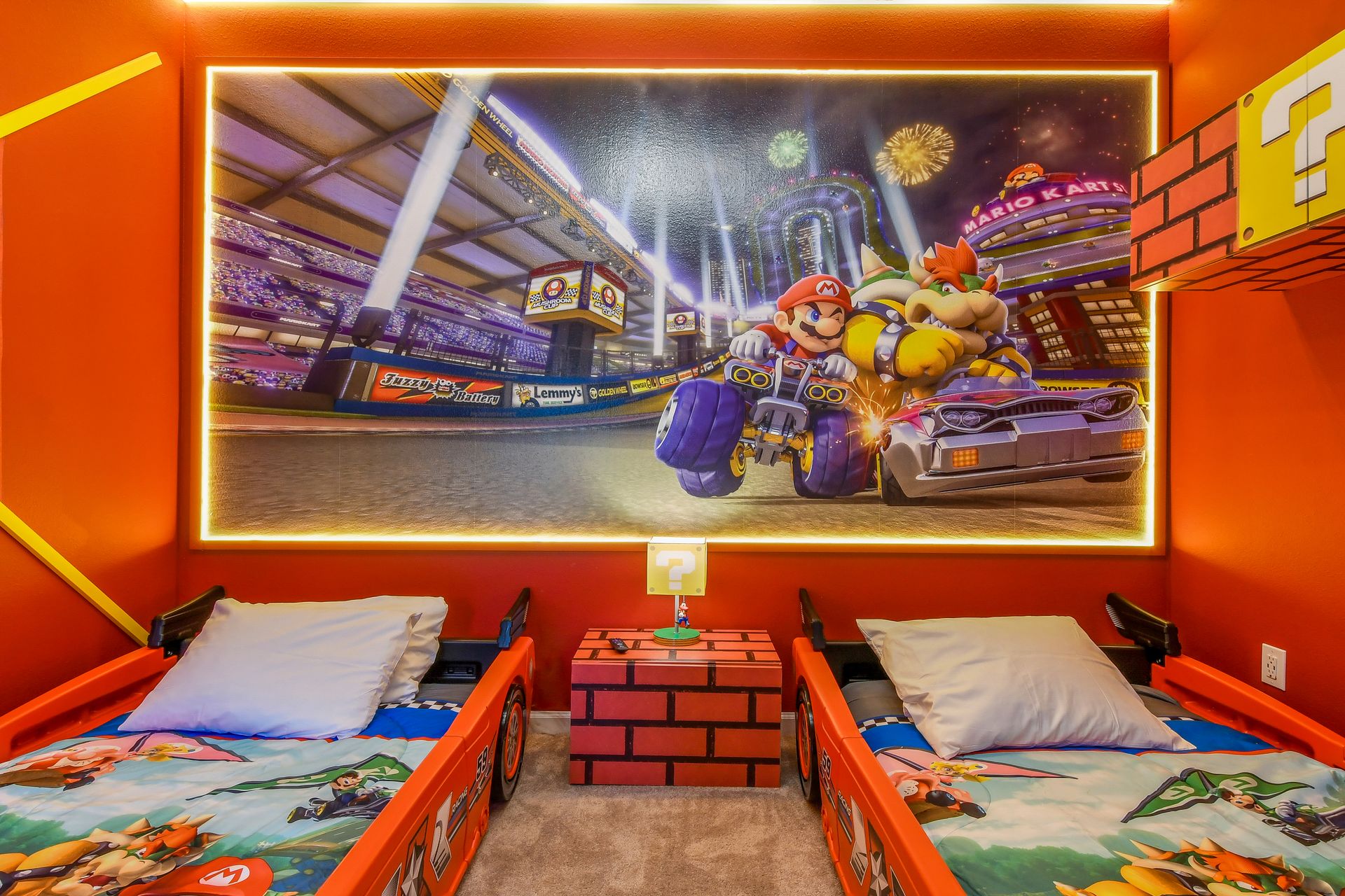 Mario Kart-inspired bedroom with race car beds, vibrant wall art, and playful details.