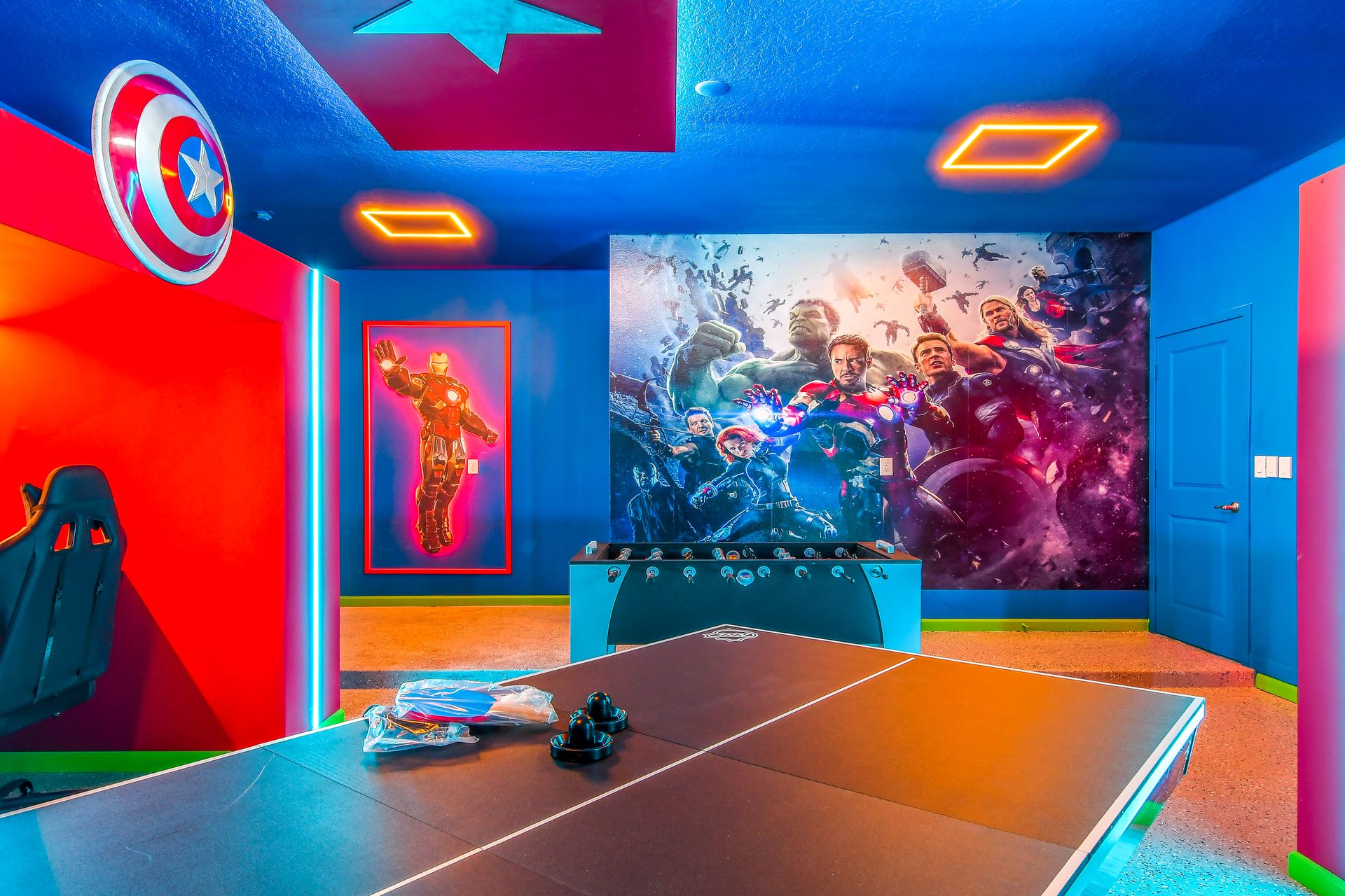 Vibrant Avengers-themed game room featuring iconic murals, neon accents, and fun activities.
