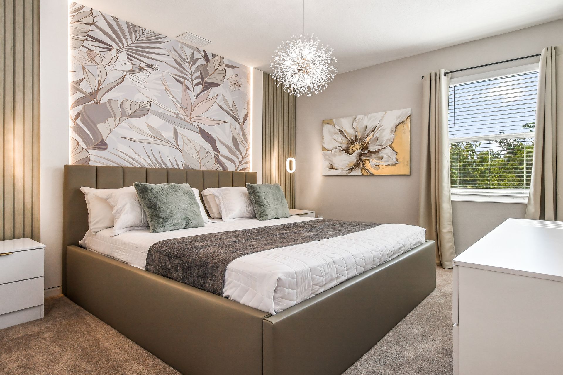 Sophisticated bedroom with botanical wallpaper, modern lighting, and soft green accents.