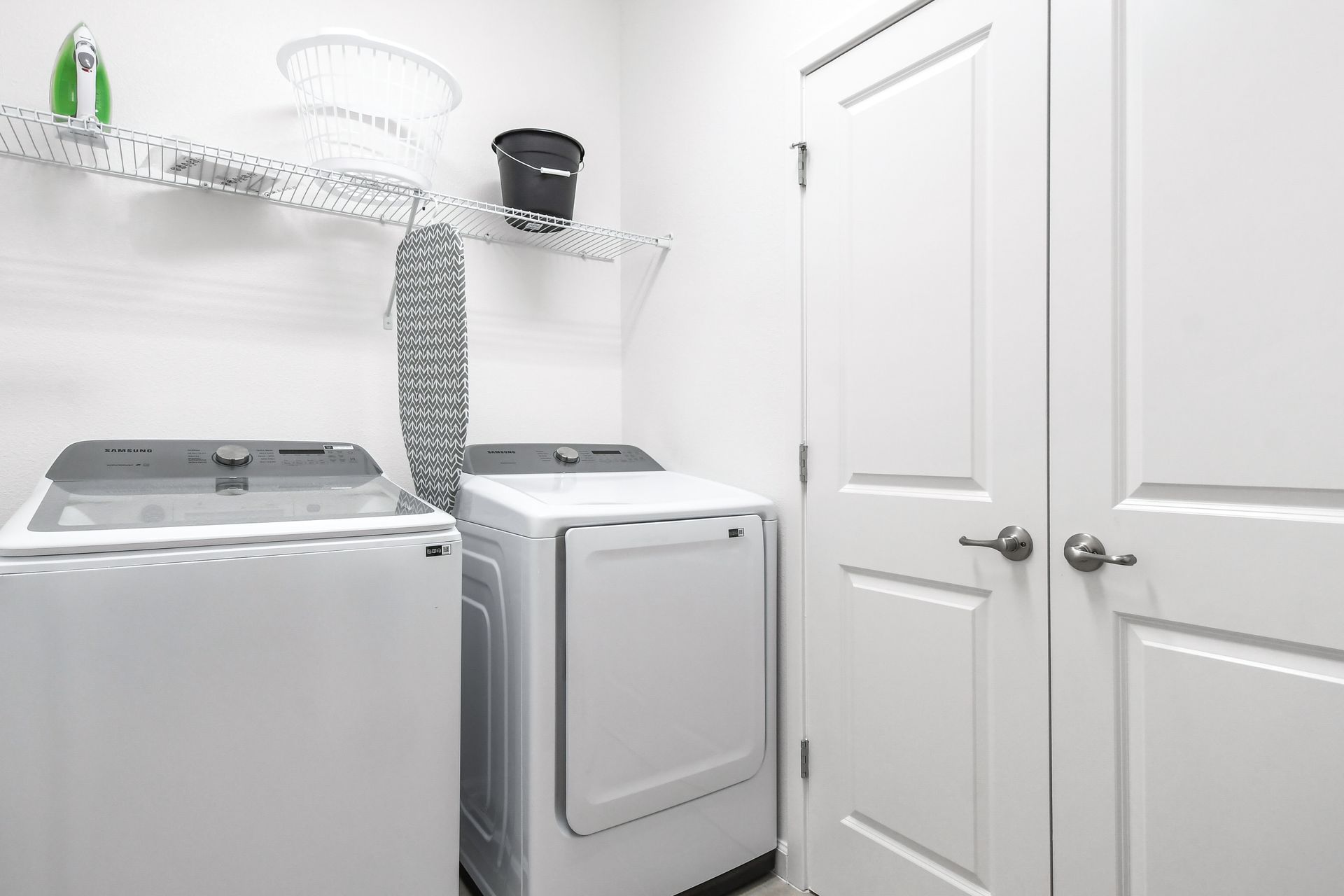 Bright and functional laundry room featuring a washer, dryer, and ample storage space.