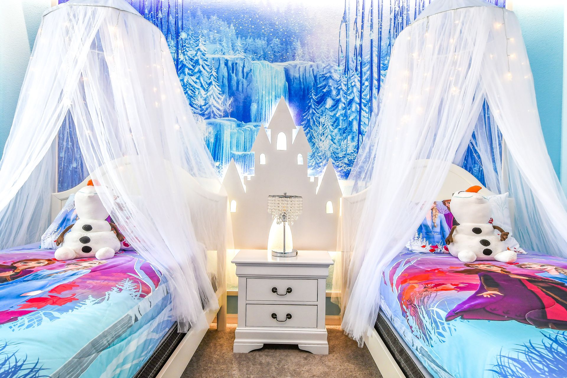 Frozen-themed bedroom with icy blue decor, whimsical canopies, and magical winter accents.