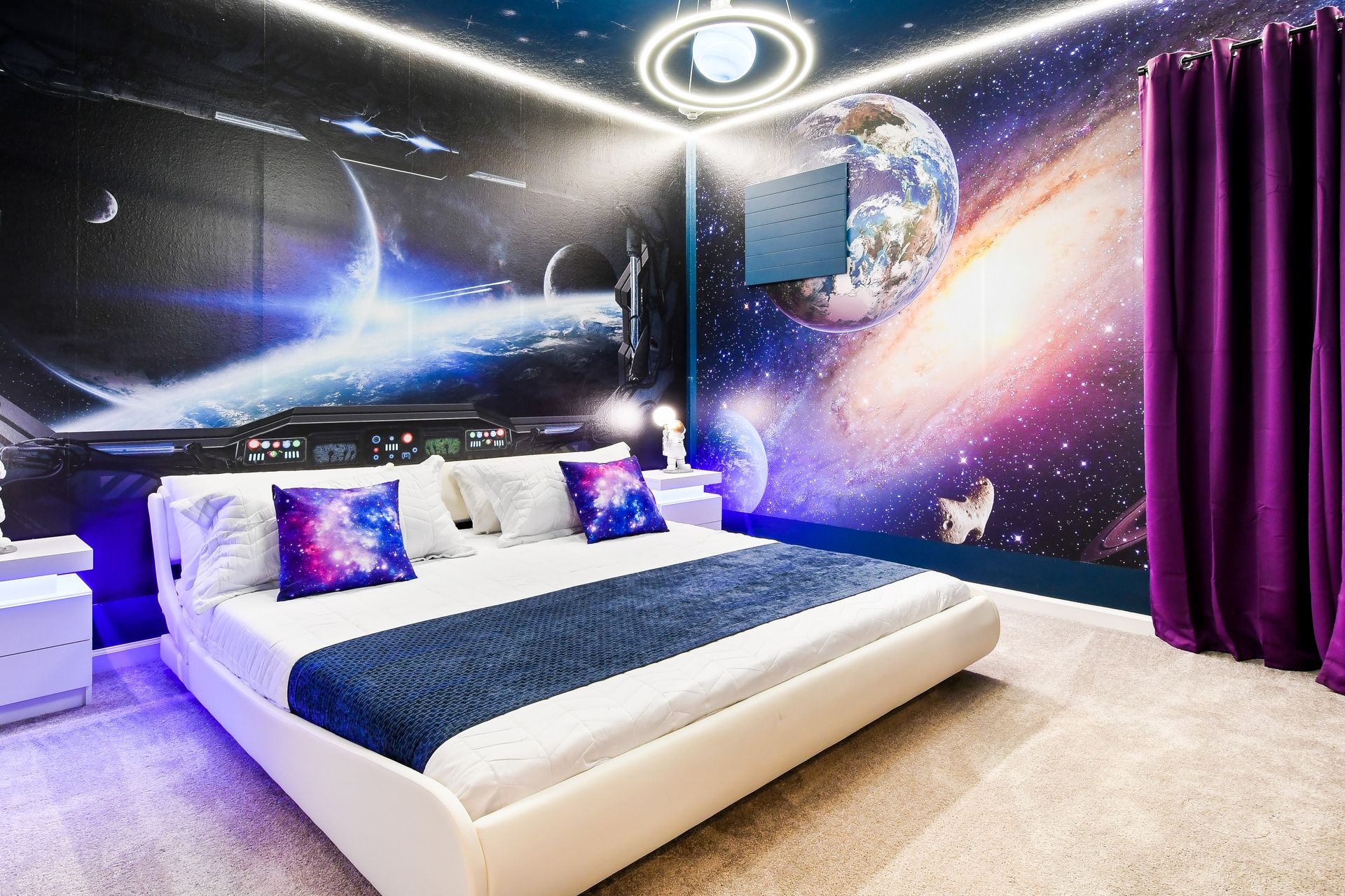 Futuristic space-themed bedroom with galaxy murals, ambient lighting, and cosmic decor.