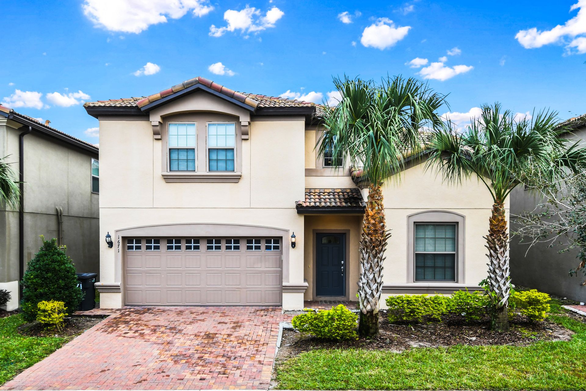 Beautiful modern villa with lush landscaping, palm trees, and a welcoming entrance!