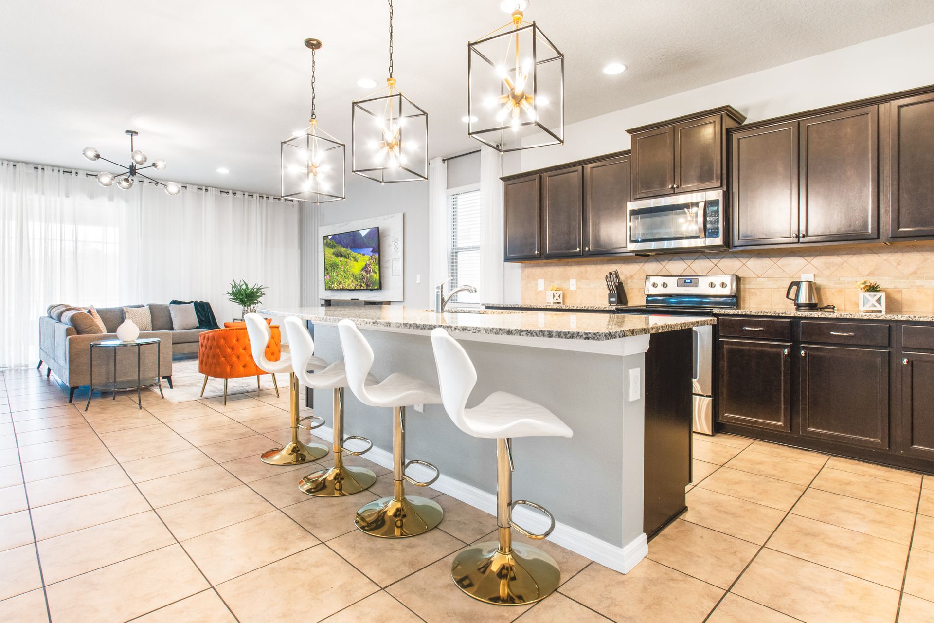 Modern kitchen with sleek dark cabinets, stylish lighting, and spacious seating!