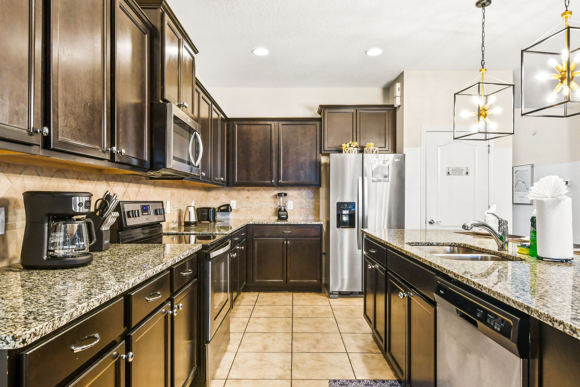 Elegant kitchen with dark wood cabinets, granite countertops, and modern appliances!
