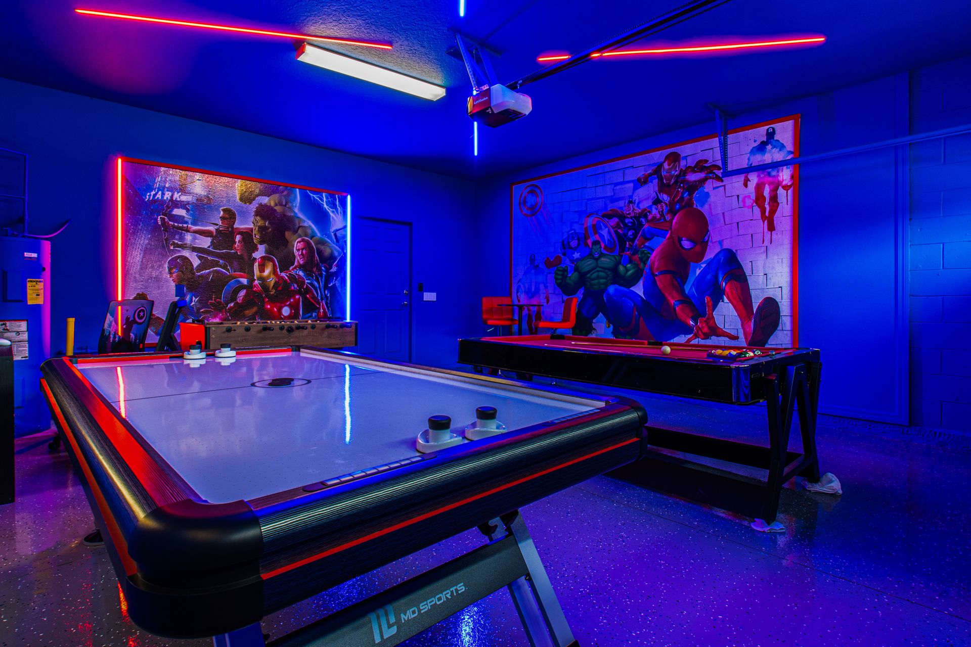 Superhero-themed game room with air hockey, pool, neon lights, and epic vibes!