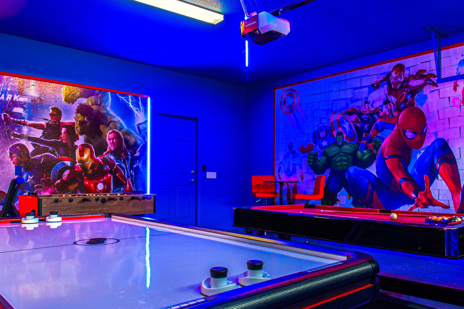 Epic superhero-themed game room with air hockey, pool, and neon-lit ambiance!