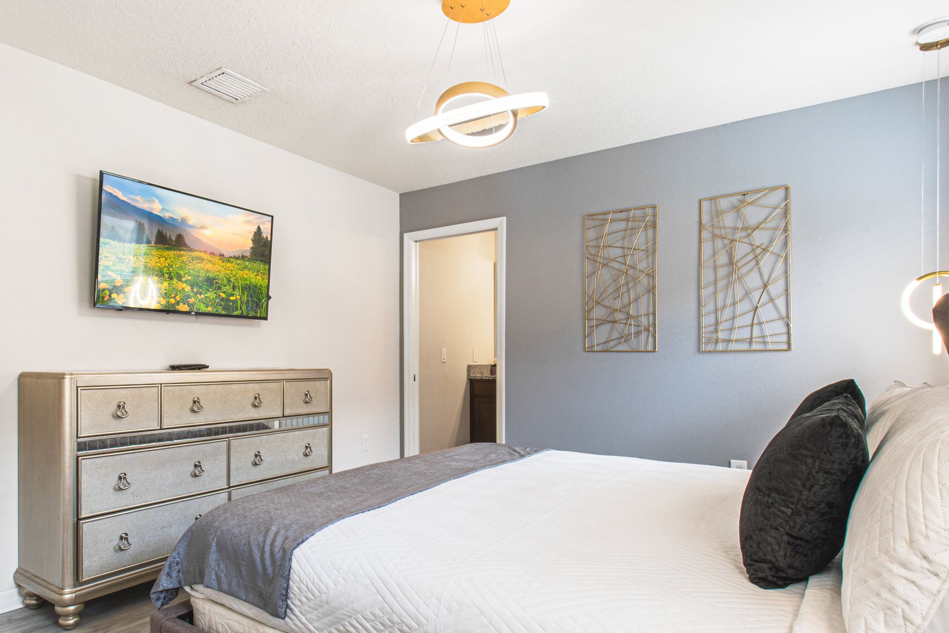 Luxurious bedroom with a plush tufted bed, modern lighting, and elegant decor!